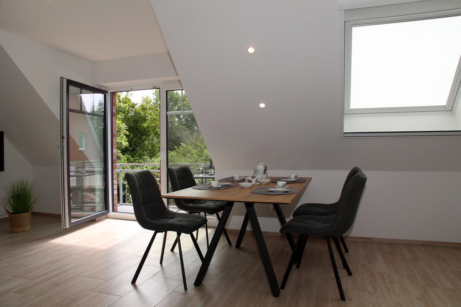 Esszimmer mit Tisch, Stühlen und Blick auf Balkon