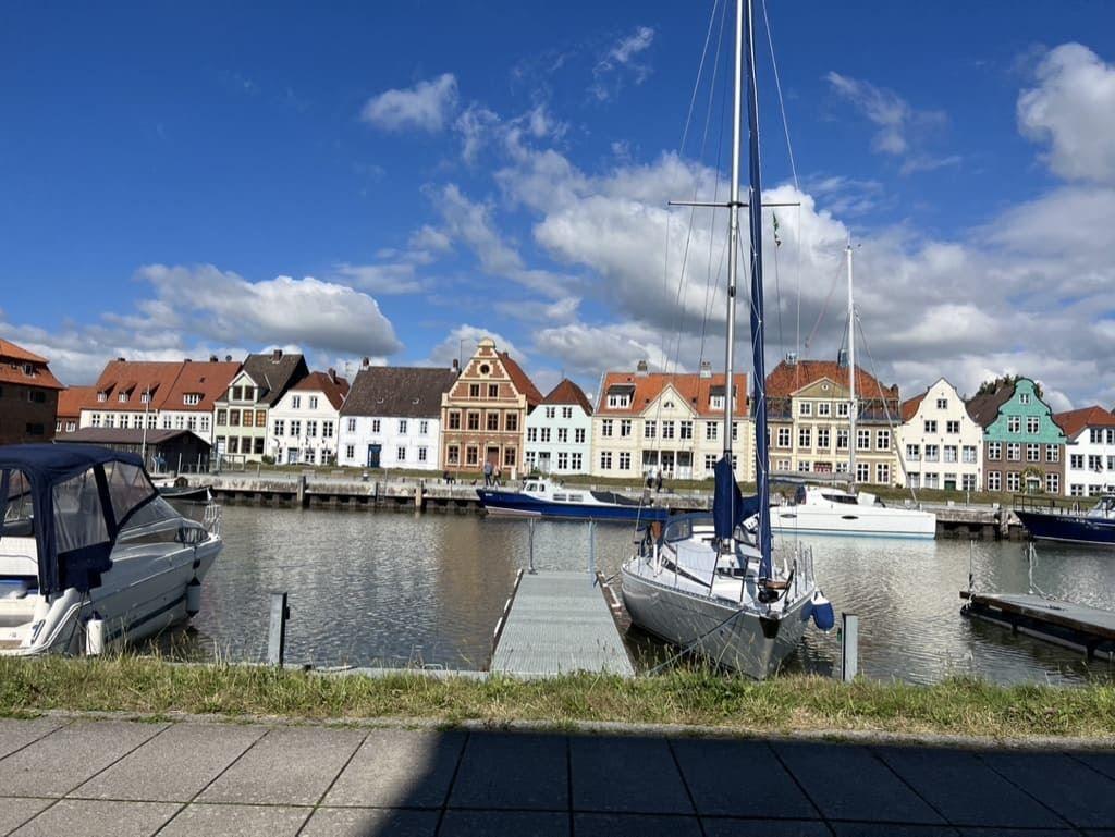 Hafen mit Booten und farbenfrohen Häusern an der Wasserseite.