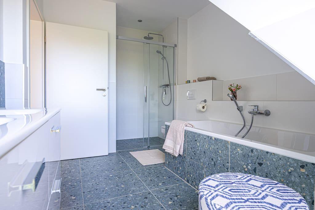 Badezimmer mit Dusche, Badewanne und Terrazzofußboden