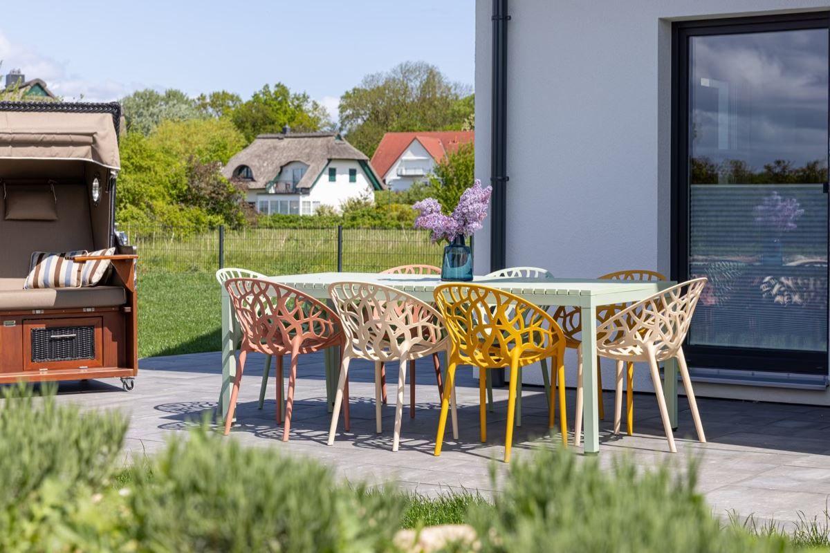 Terrasse mit Tisch und Stühlen, Gartenmöbel und Blick auf die Umgebung.