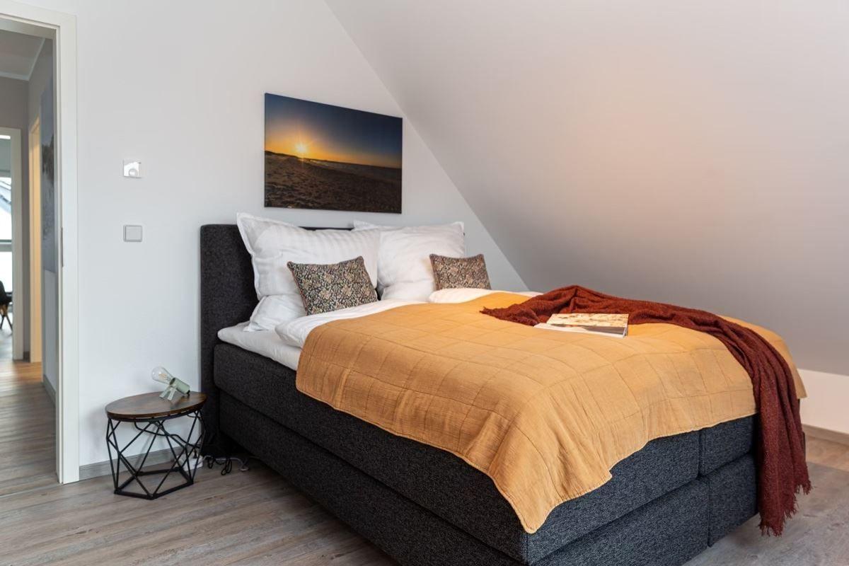 Schlafzimmer mit Doppelbett, Wandbild und Nachttisch.