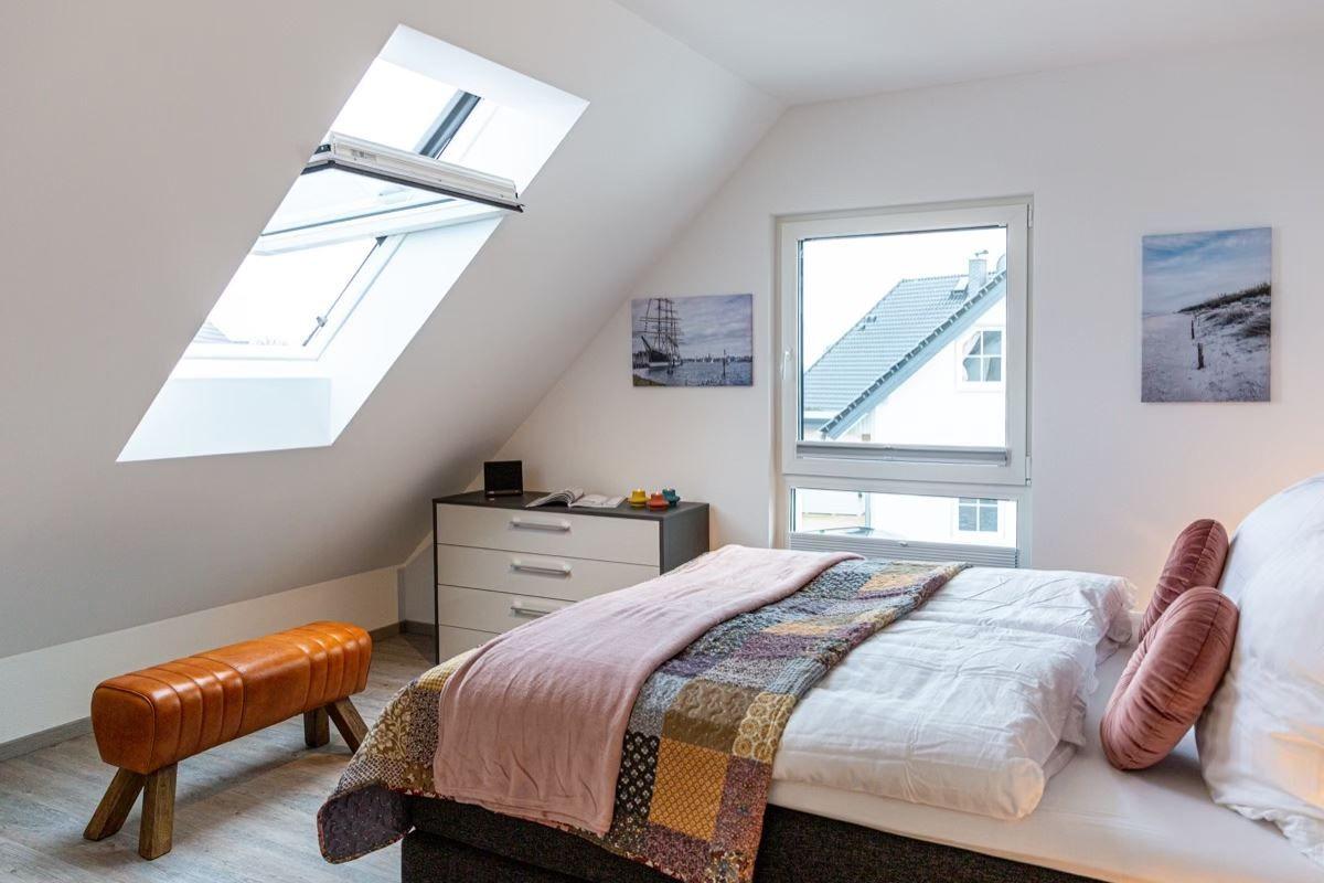 Schlafzimmer mit Dachschrägen, Dachfenster, Bett und Schrank.