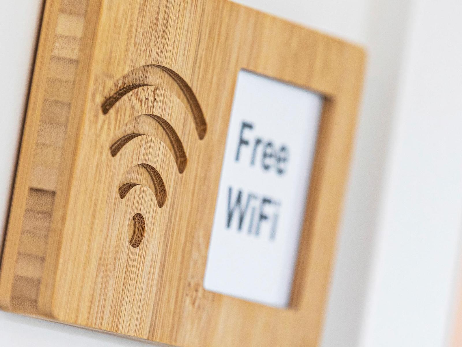 Holzschild mit WLAN-Symbol und Aufkleber Free WiFi.
