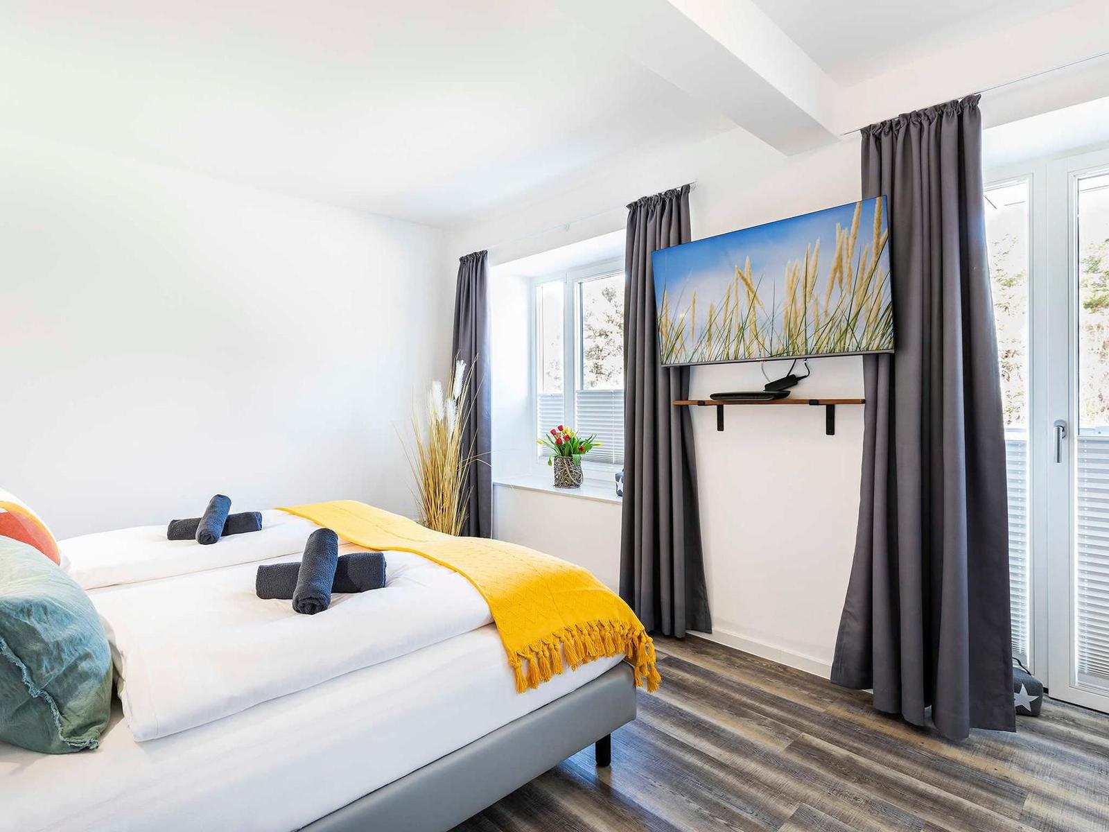 Schlafzimmer 1: Doppelbett (180x200), TV, Zugang zum Balkon