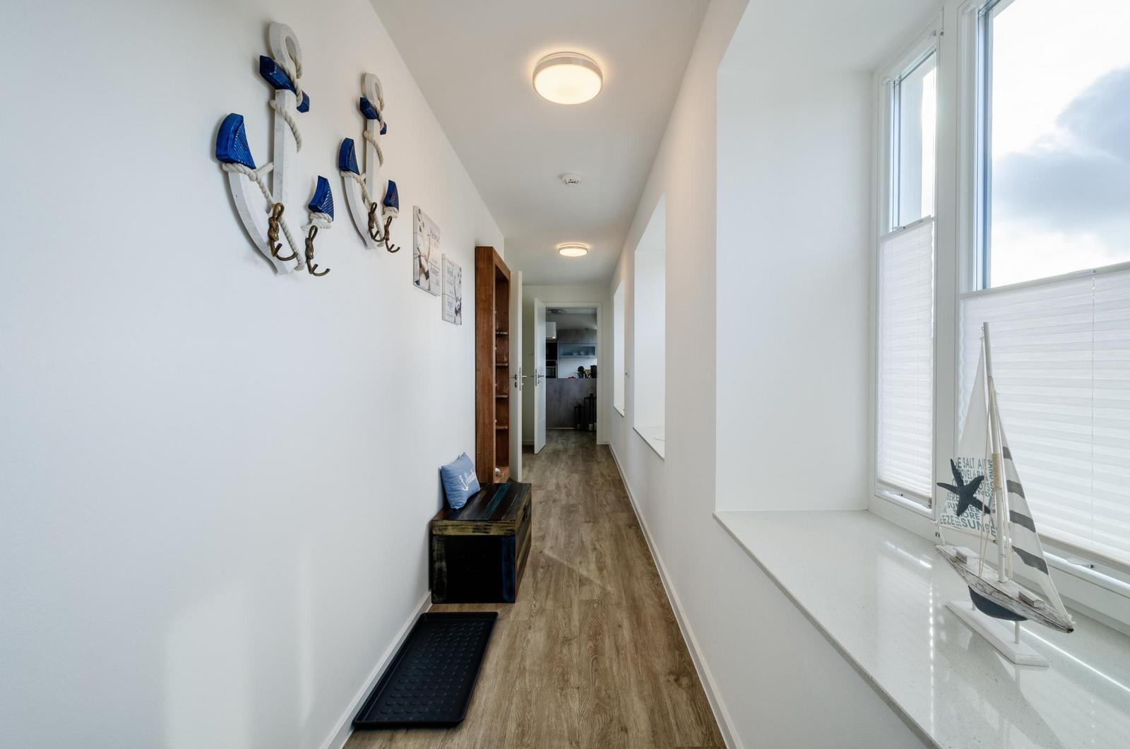 Flur mit Holzboden, Fensterbank und Ankerdekoration an der Wand.