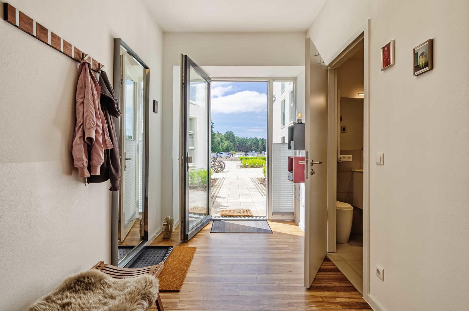 Entrance area with coat rack, mirror, and view of the outdoor terrace.