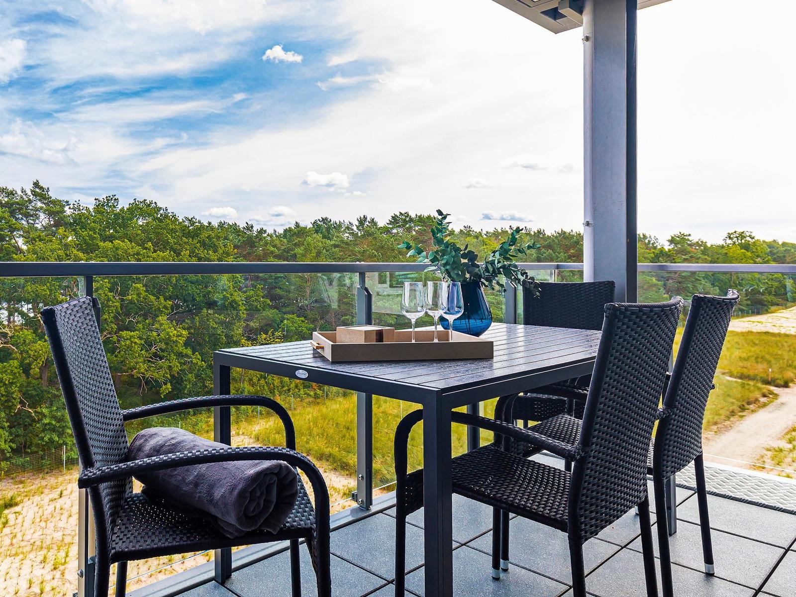Terrasse mit Tisch, Stühlen und Blick auf Wald