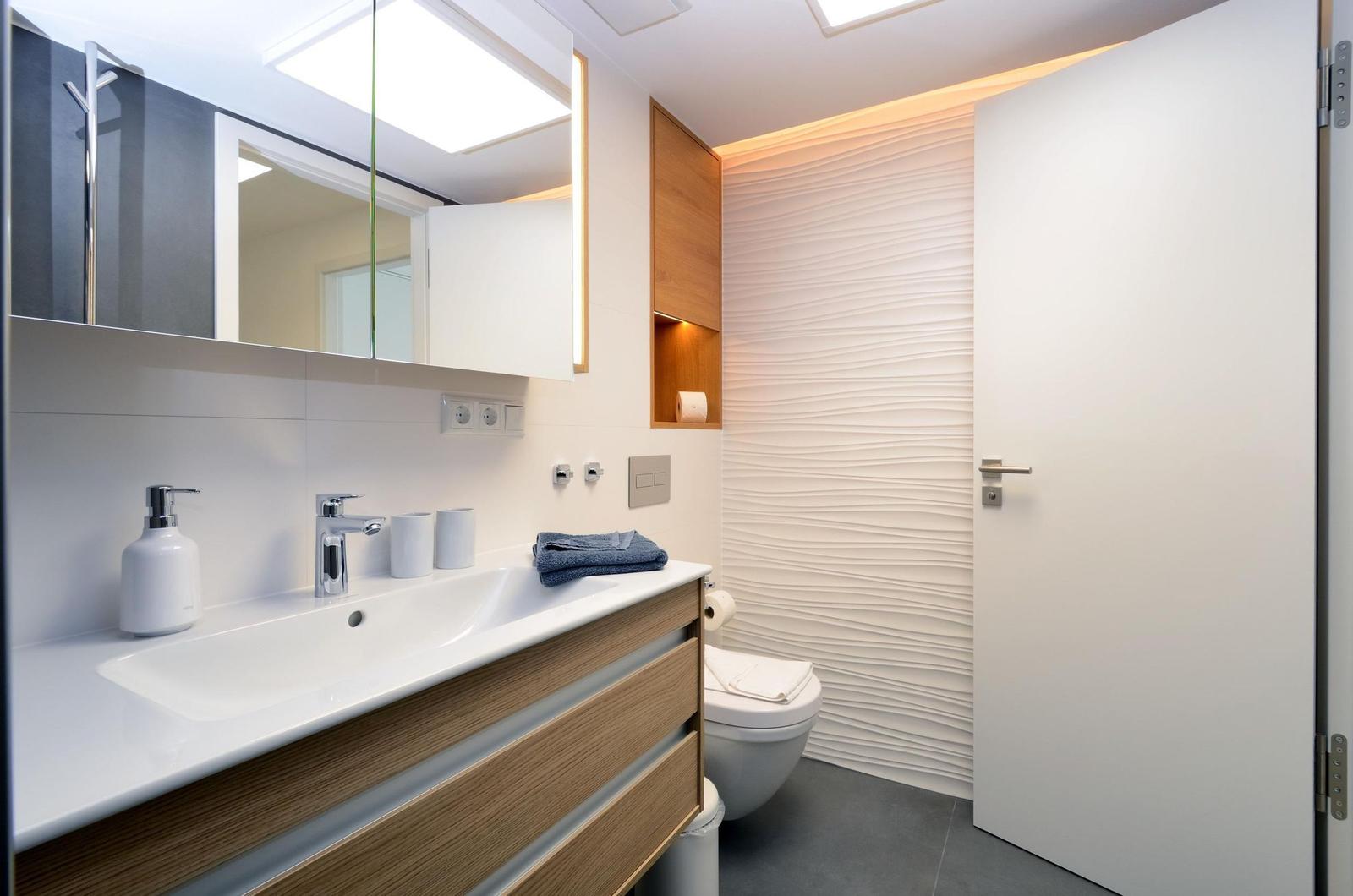 Badezimmer: Regendusche, WC, Haartrockner, beleuchtete Badespiegel