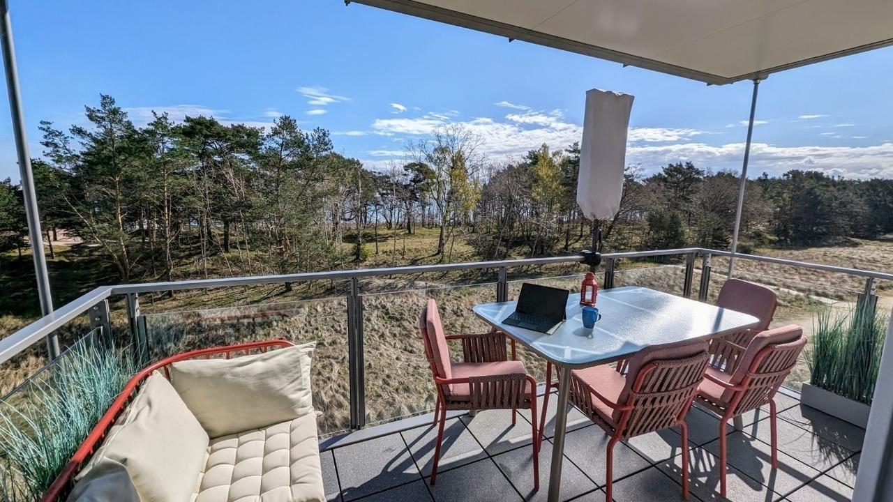 Terrasse mit Tisch, Stühlen und Blick auf Wald