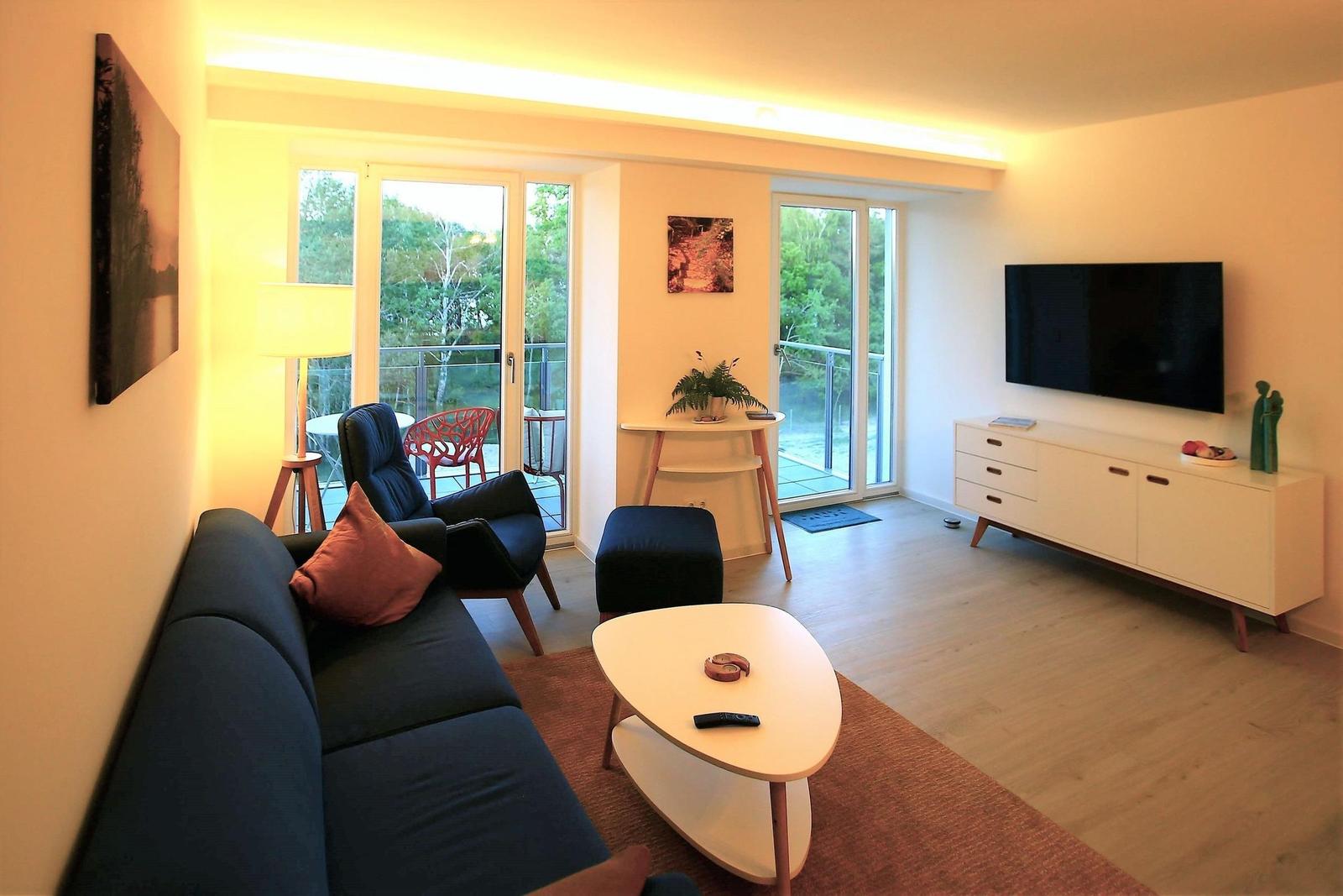 Wohn/Essbereich: Sofa, Sessel, TV, Zugang zum Balkon