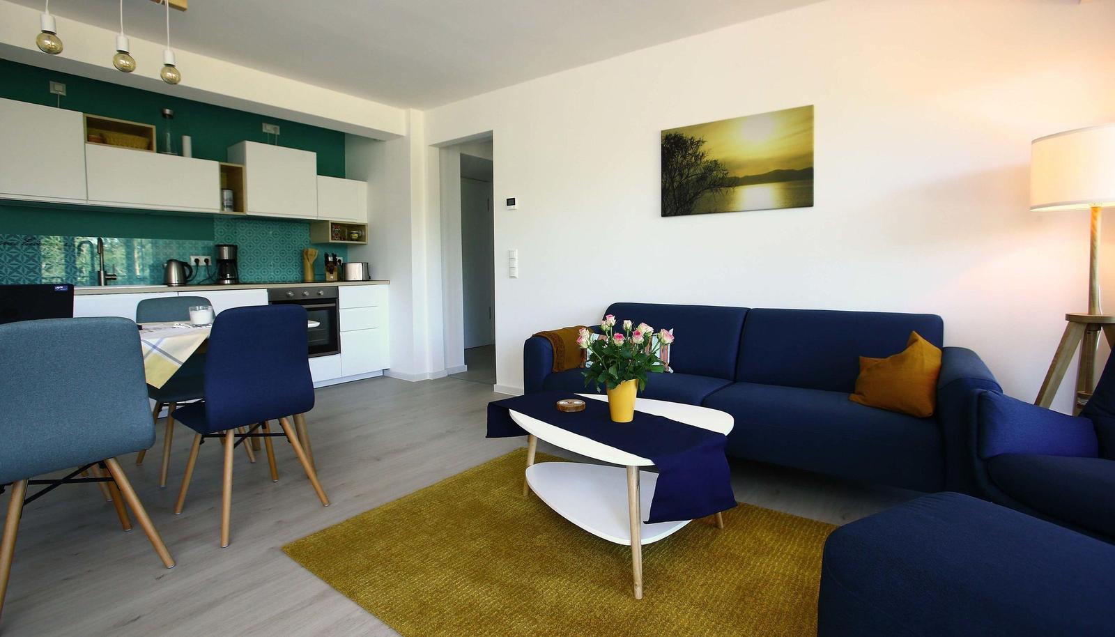 Wohn/Essbereich: Sofa, Sessel, TV, Zugang zum Balkon