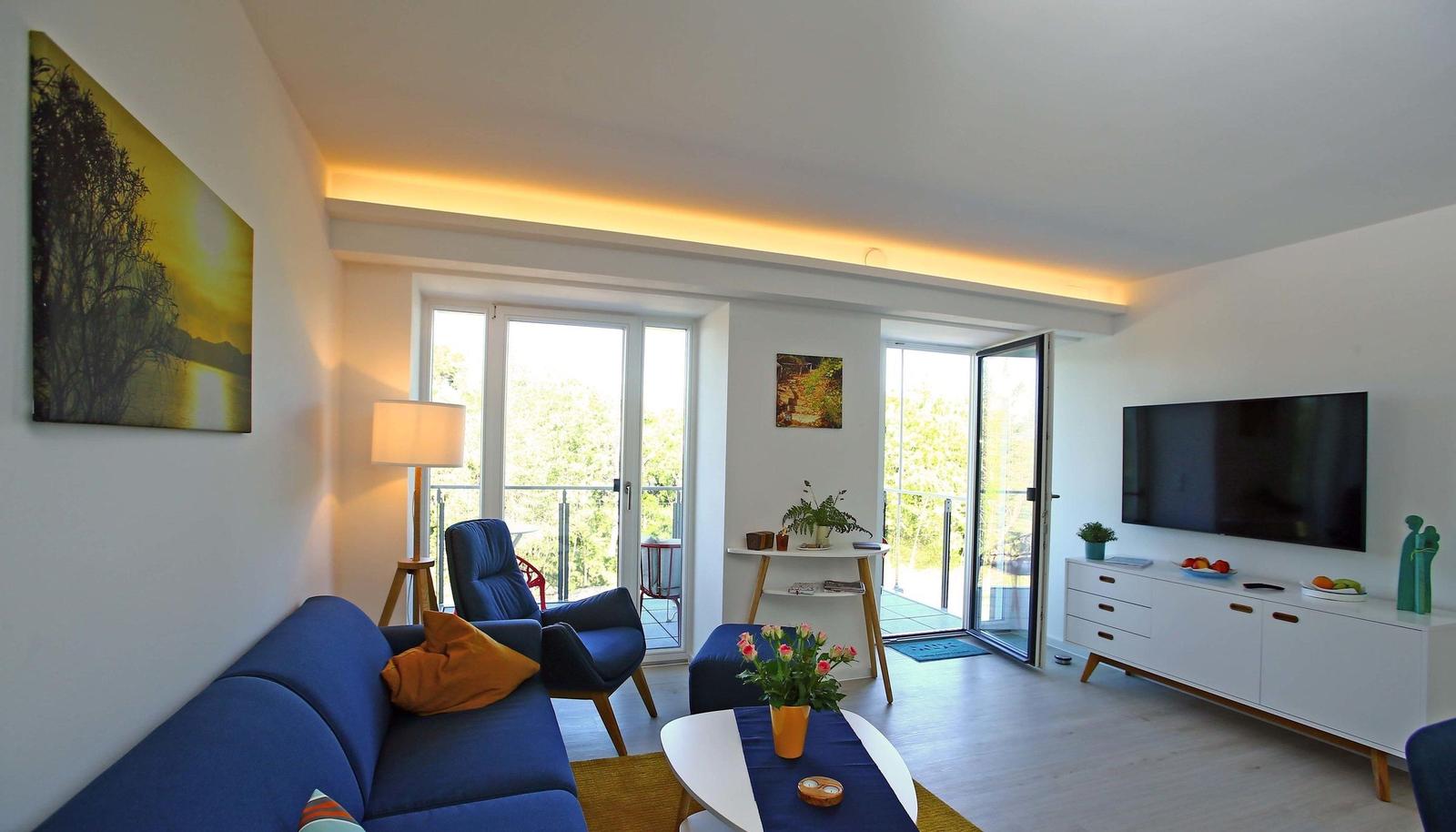 Wohn/Essbereich: Sofa, Sessel, TV, Zugang zum Balkon