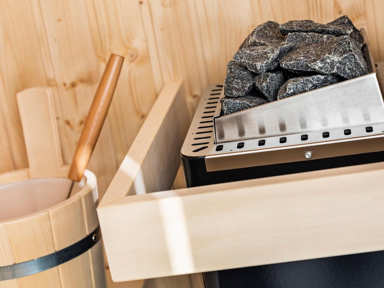 Sauna mit Steinofen und Holzwaschbecken