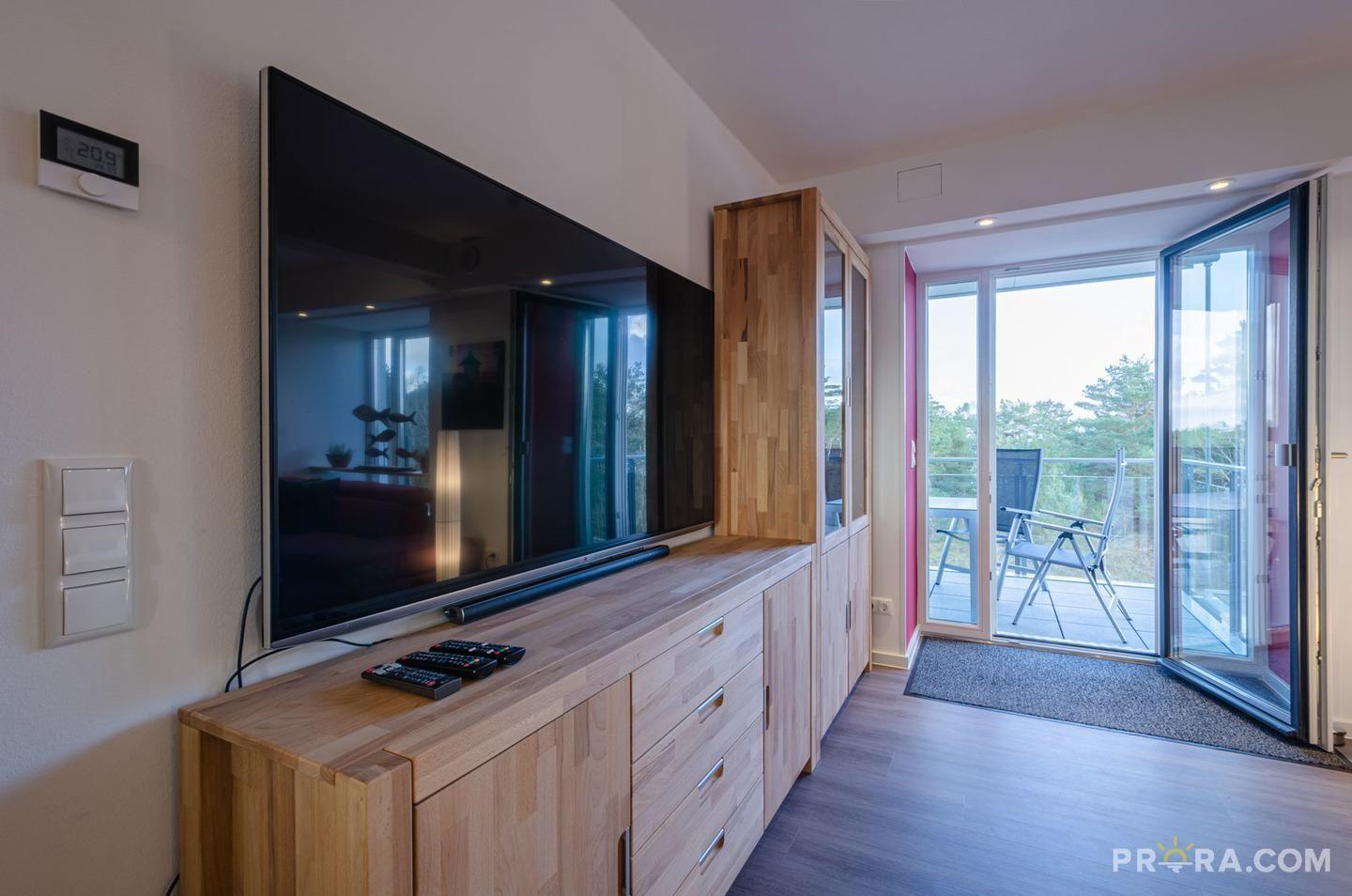 Wohn/Essbereich: Couch und Sessel, TV, Zugang zum Balkon