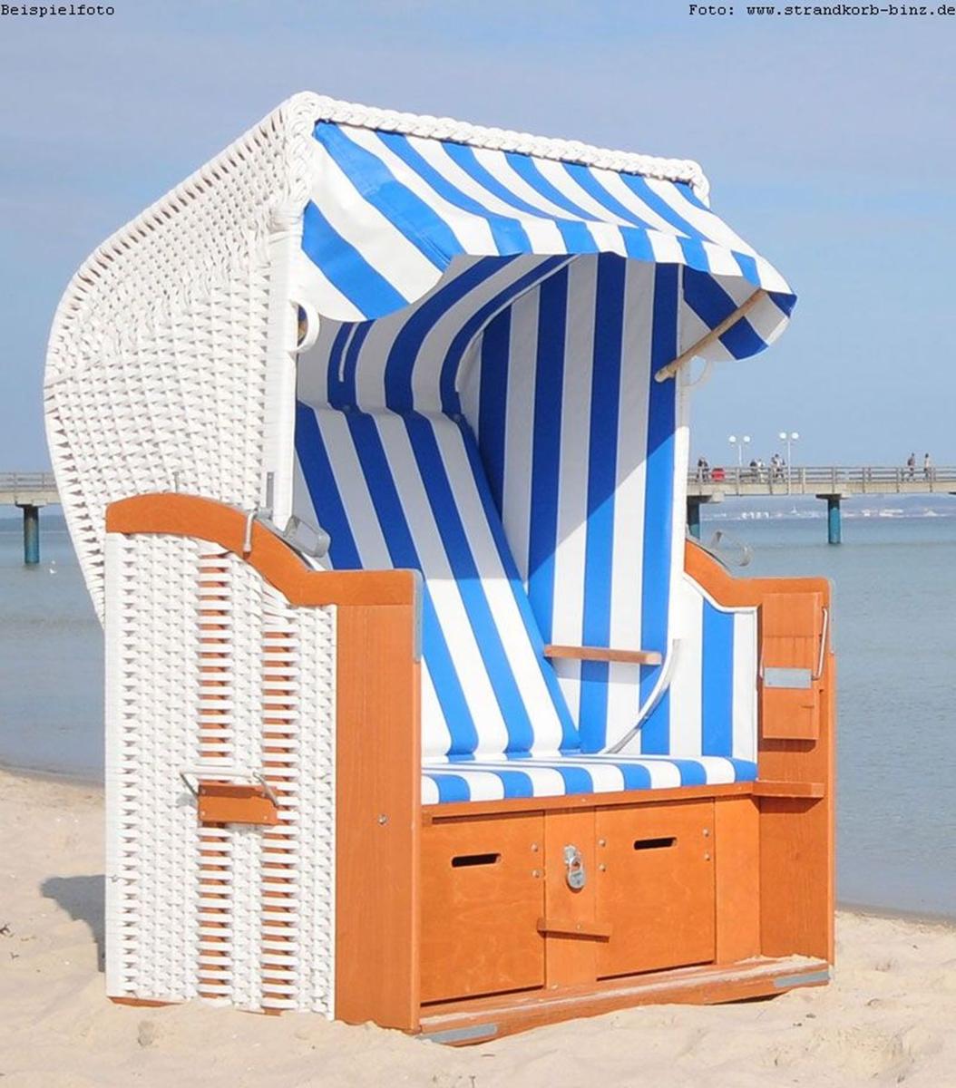 Strandkorb mit blau-weißem Streifenmuster auf Sand