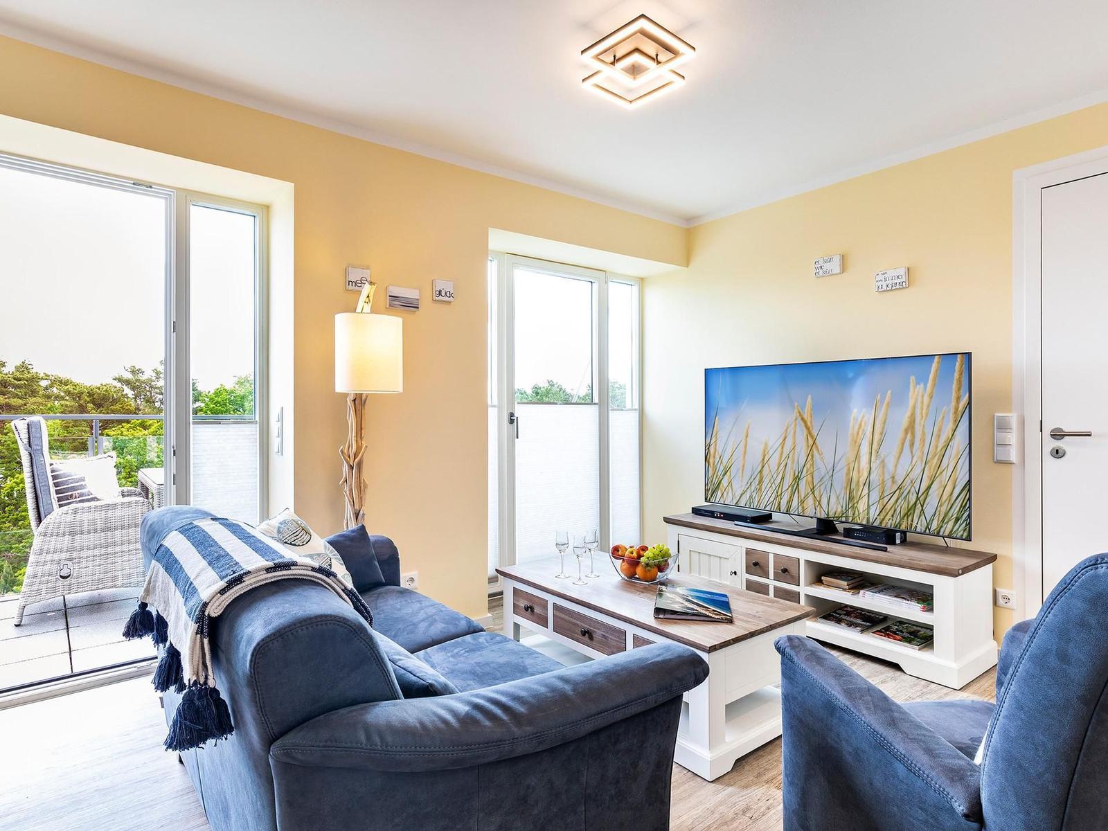 Wohn- und Essbereich: Sofa, TV, Blue Ray Player, Safe, Zugang zum Balkon