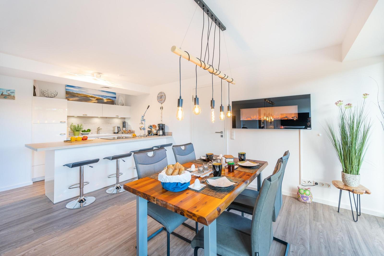 Wohn/Essbereich: Sofa, Sitzbereich, Essbereich, TV, Elektrokamin, Zugang zum Balkon
