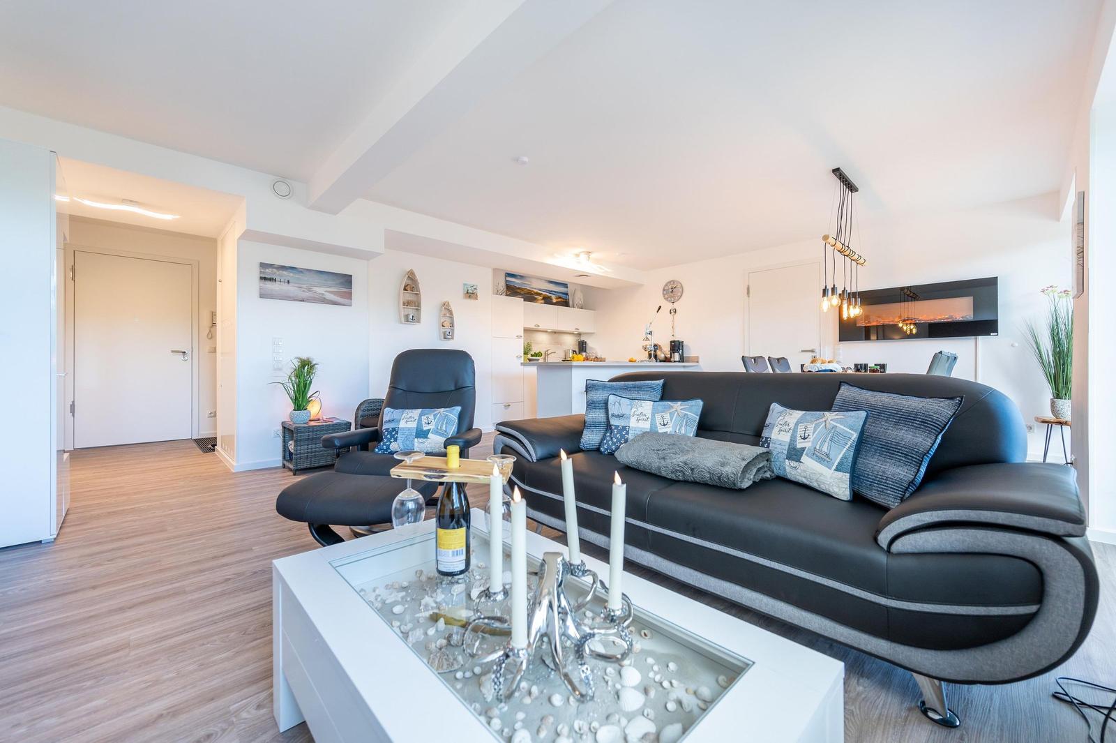 Wohn/Essbereich: Sofa, Sitzbereich, Essbereich, TV, Elektrokamin, Zugang zum Balkon