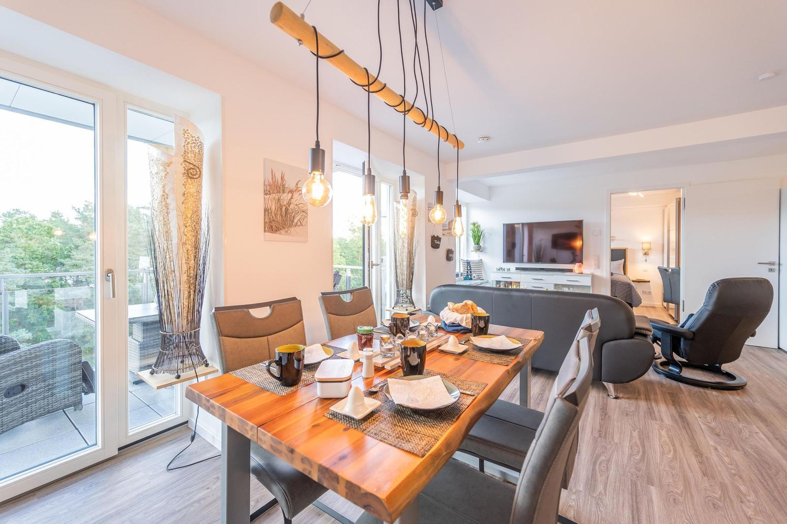 Wohn/Essbereich: Sofa, Sitzbereich, Essbereich, TV, Elektrokamin, Zugang zum Balkon
