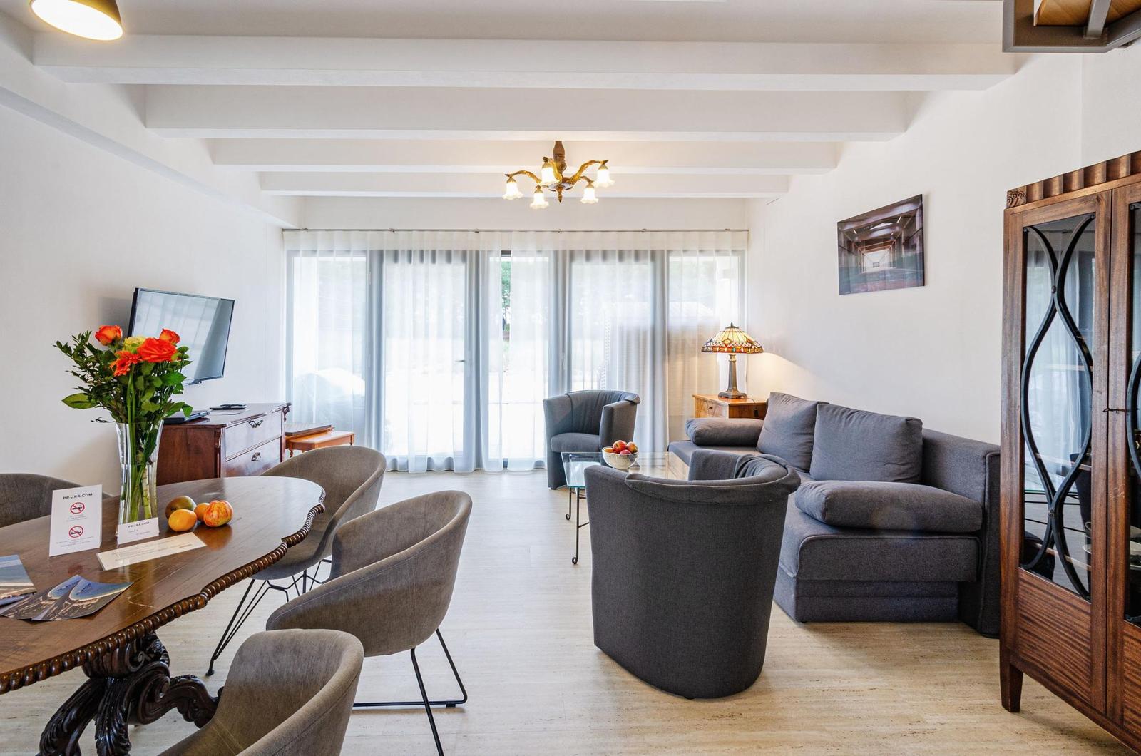 Wohnzimmer: Sofa, TV, Zugang zur Terrasse