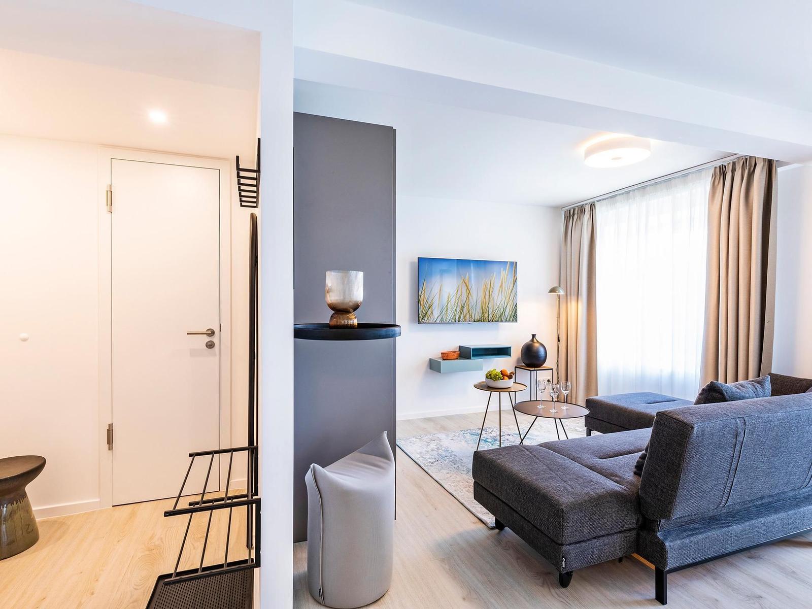 Wohnzimmer: Schlafsofa, TV, Zugang zum Balkon