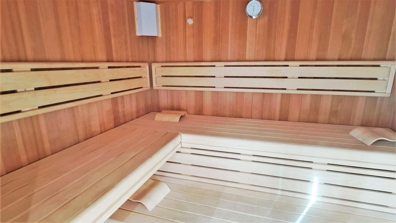 Sauna mit Holzbänken und Wanduhr