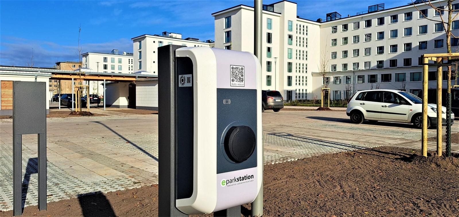 E-Ladesäule im Außenbereich vor modernen Gebäuden.