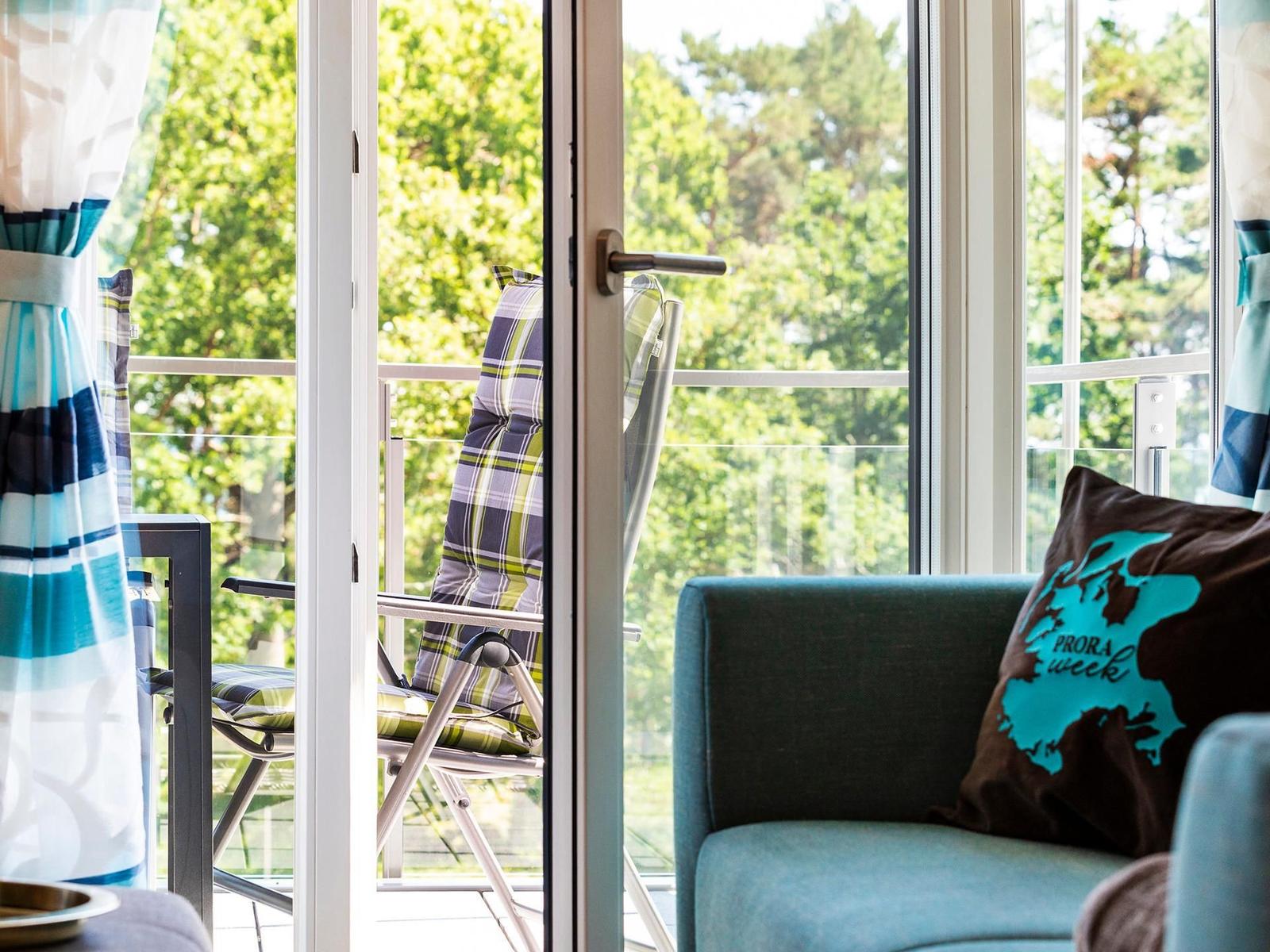 Wohn-/Essbereich: Sitzgruppe mit Couch und Sessel, Smart-TV, Zugang zum Balkon, Esstisch mit 5 Stühlen
