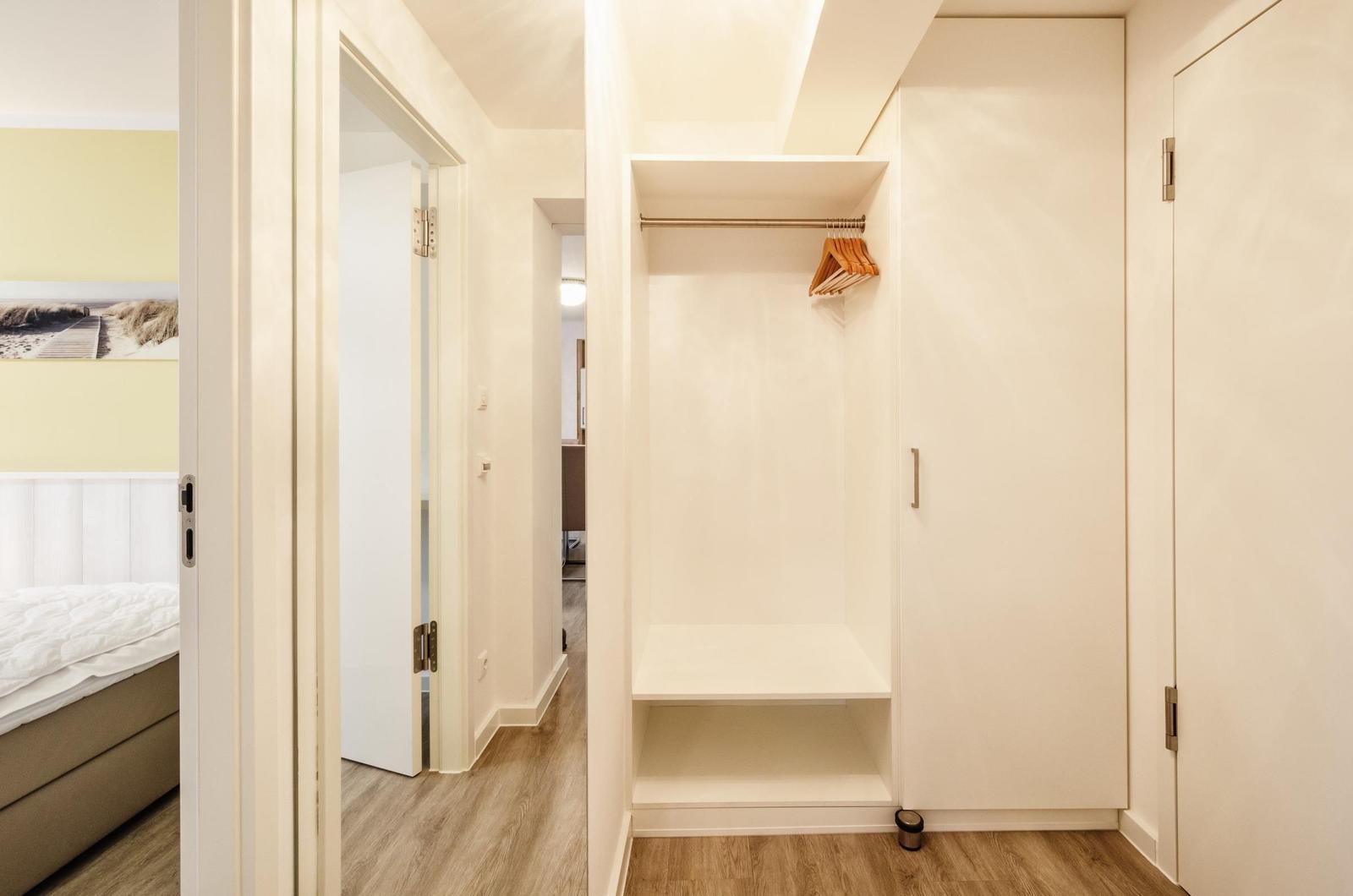 Schlafzimmer mit Kleiderschrank und Blick in den Flur.