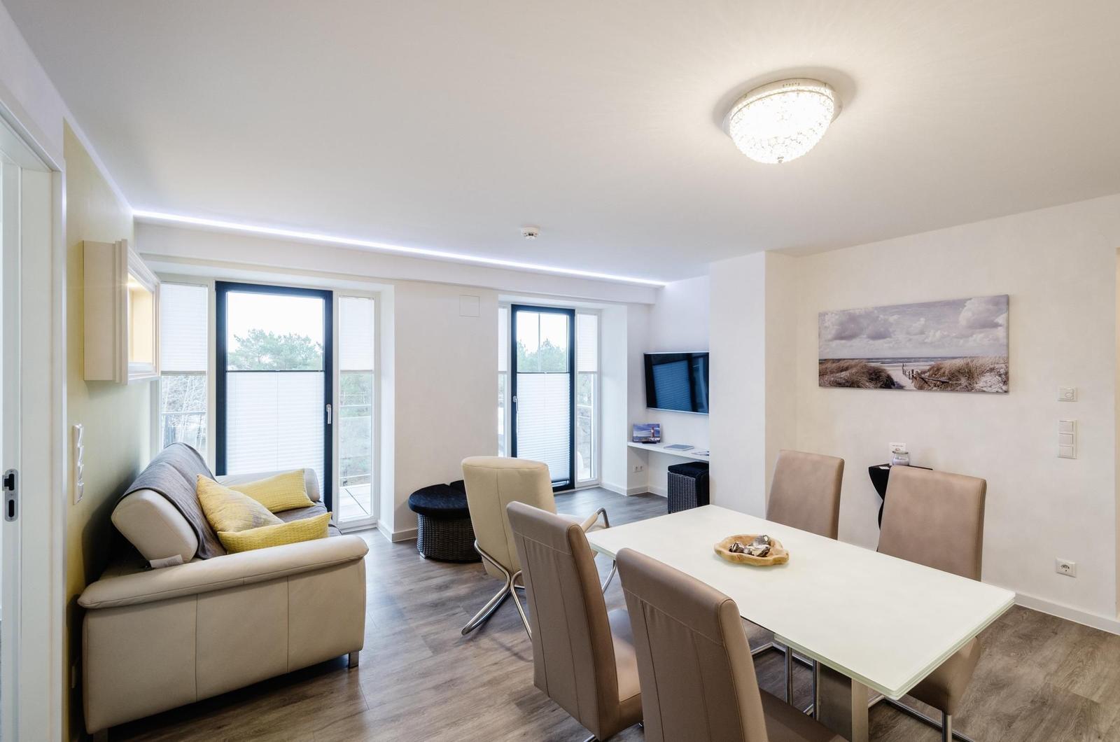 Wohnzimmer: Schlafsofa, TV, Essbereich, Zugang zum Balkon