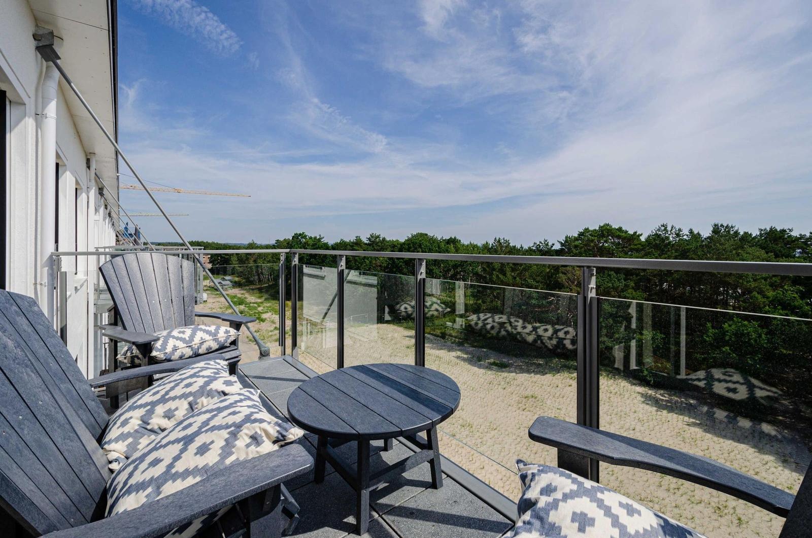 Terrasse mit Sitzgelegenheiten und Blick auf Wald.
