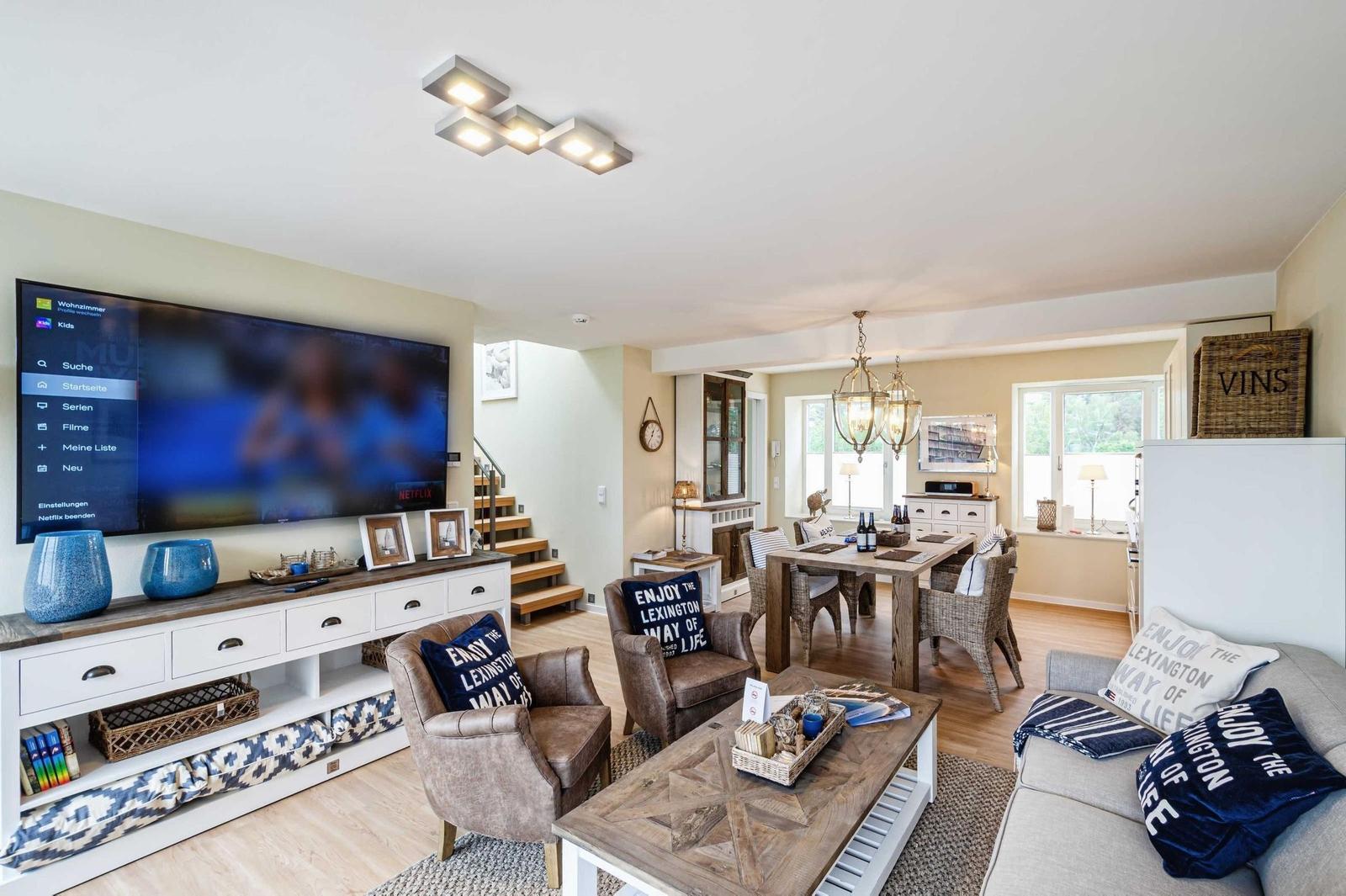 Wohnbereich/Essbereich: Sofa, TV, Treppenaufgang zur Dachterrasse, Zugang zum Balkon