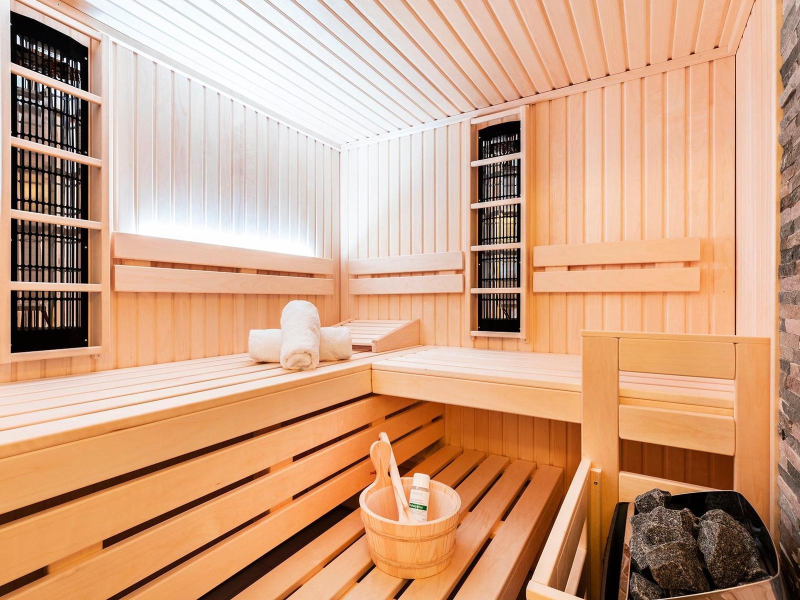 Sauna mit Holzbank, Handtuch und Eimer mit Werkzeug