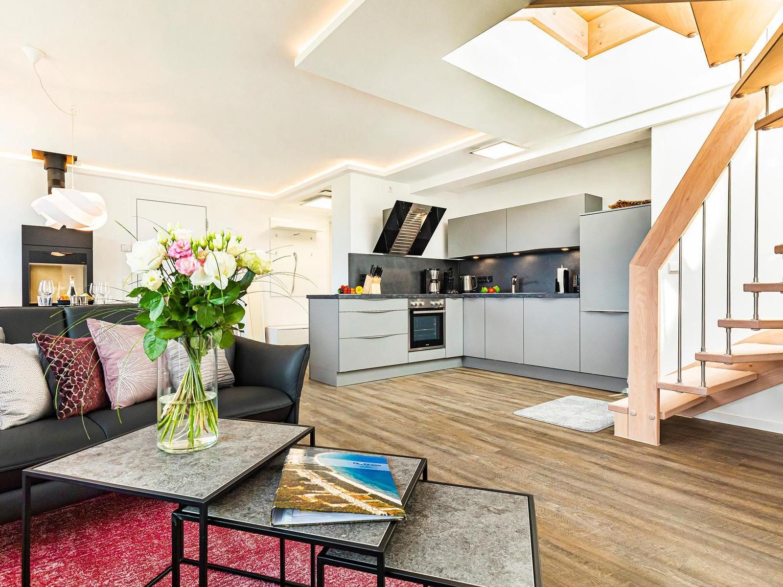 Wohnbereich/Essbereich: Sofa, TV, Beschattungs-Plissess, Treppenaufgang zur Dachterrasse, Zugang zum Balkon