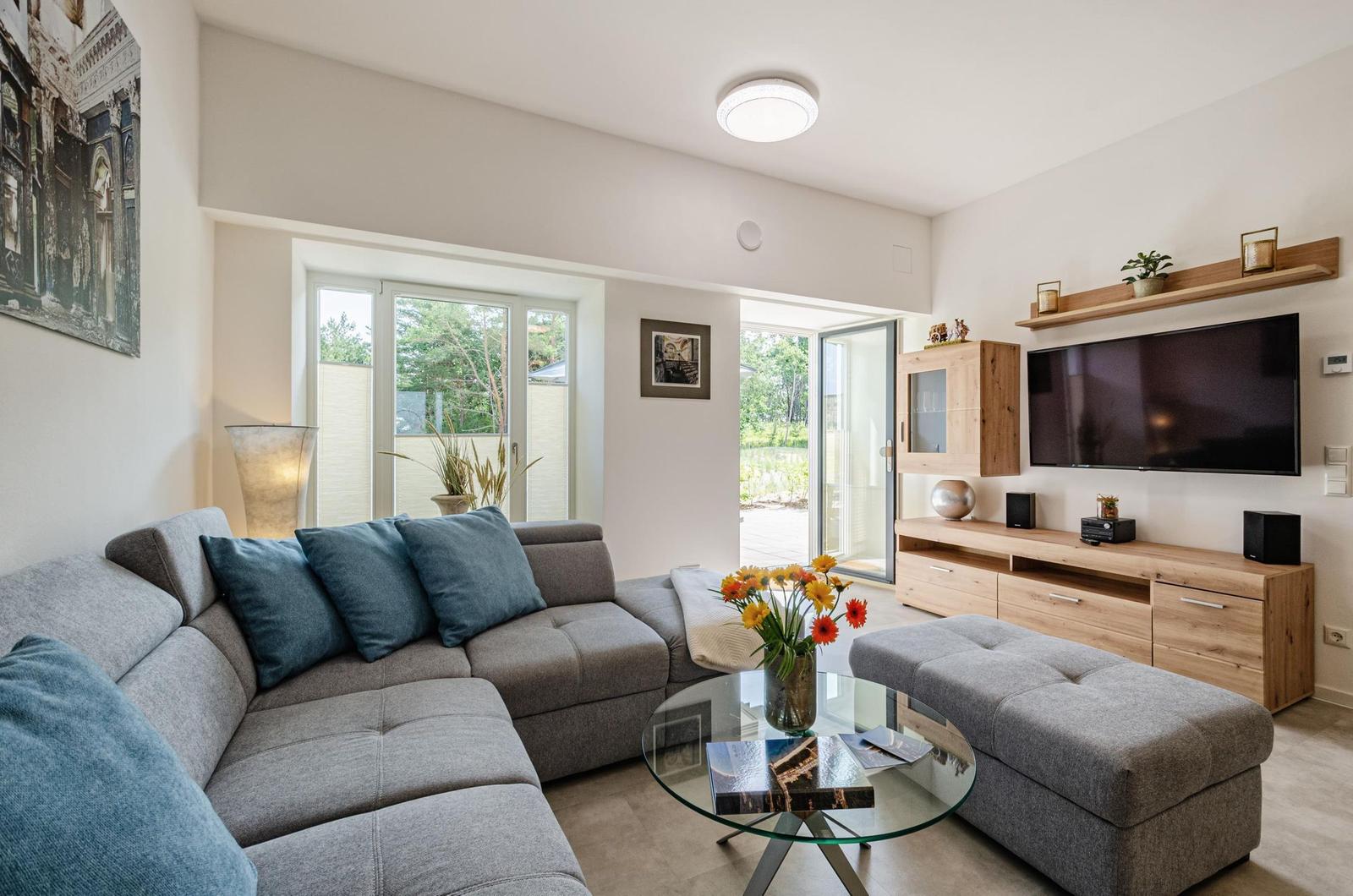 Wohnzimmer: Schlafsofa und Sessel, TV, Essbereich, Zugang zur Terrasse