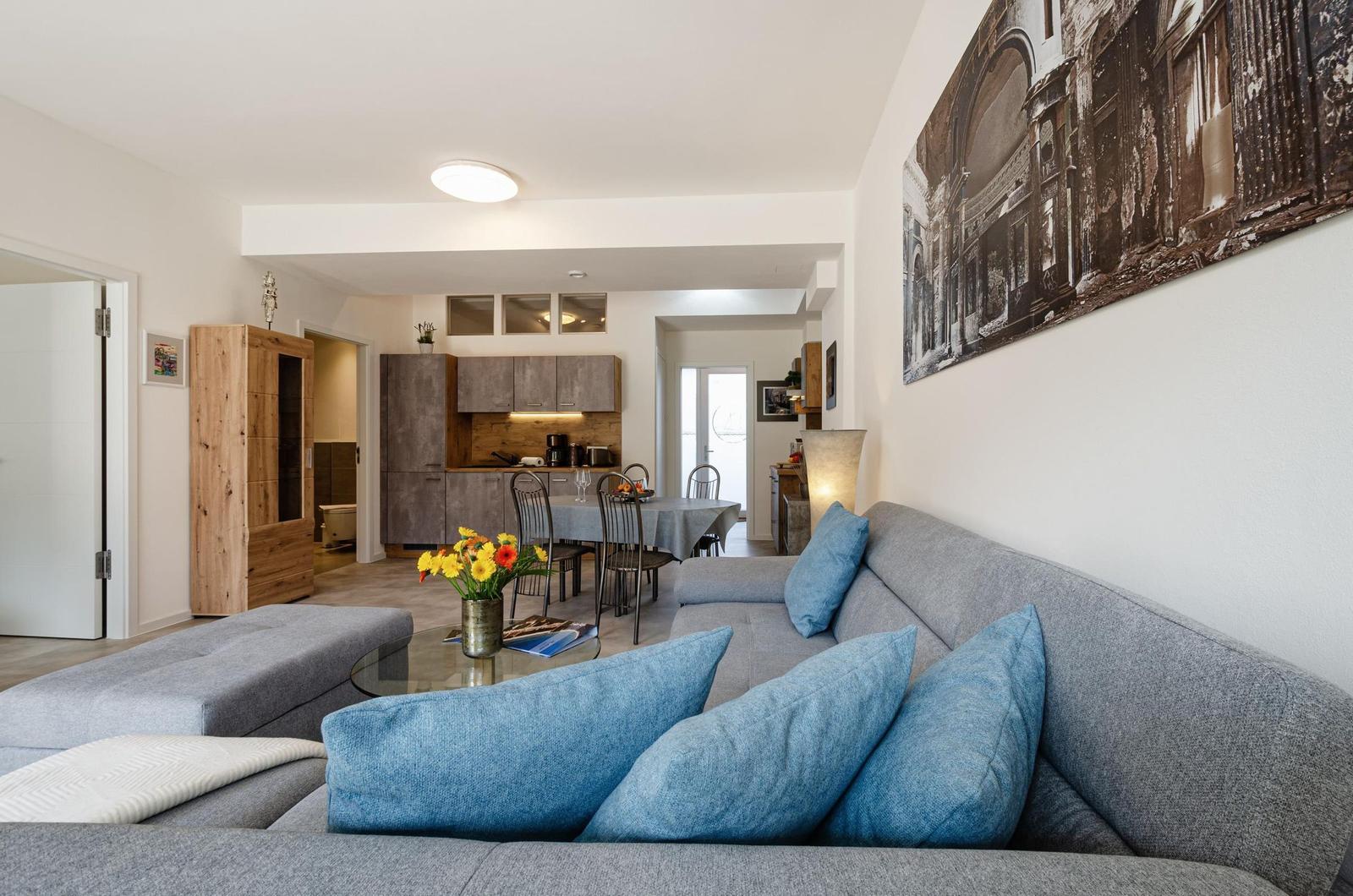 Wohnzimmer: Schlafsofa und Sessel, TV, Essbereich, Zugang zur Terrasse