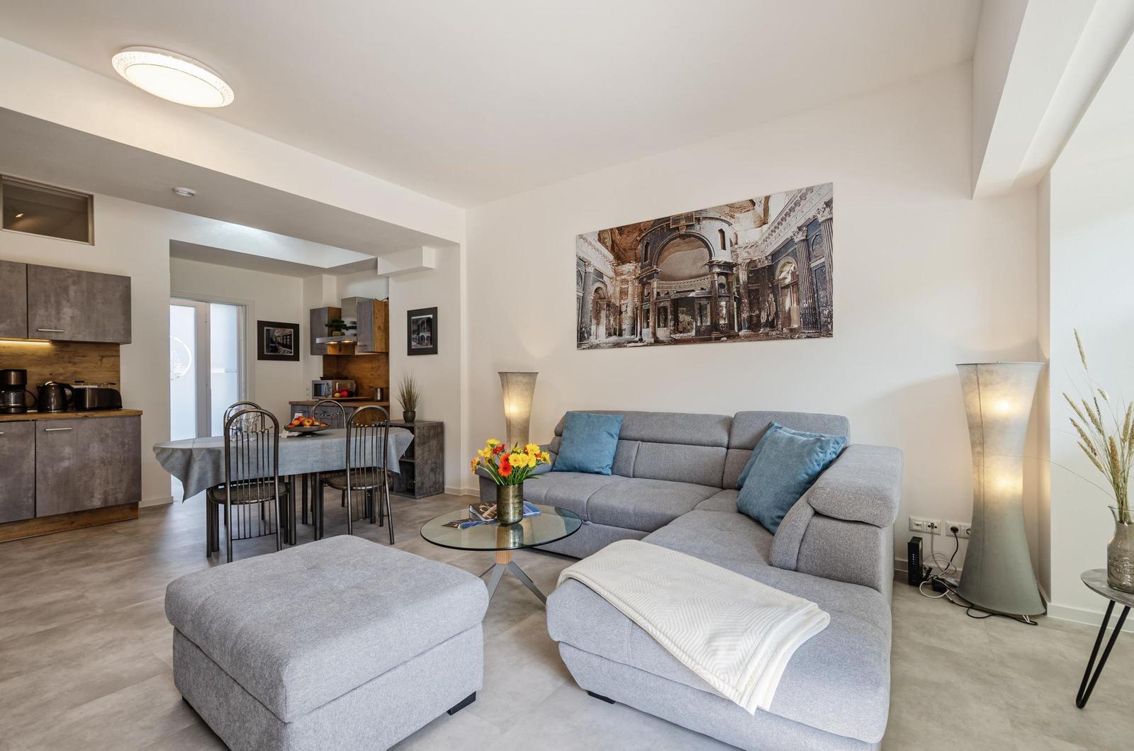 Wohnzimmer: Schlafsofa und Sessel, TV, Essbereich, Zugang zur Terrasse