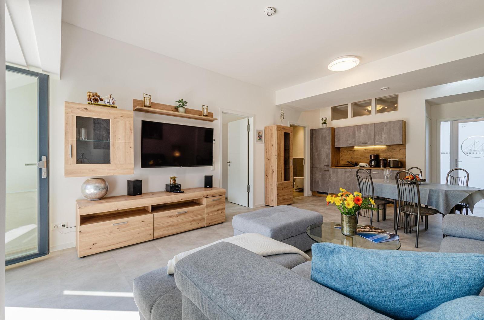 Wohnzimmer: Schlafsofa und Sessel, TV, Essbereich, Zugang zur Terrasse