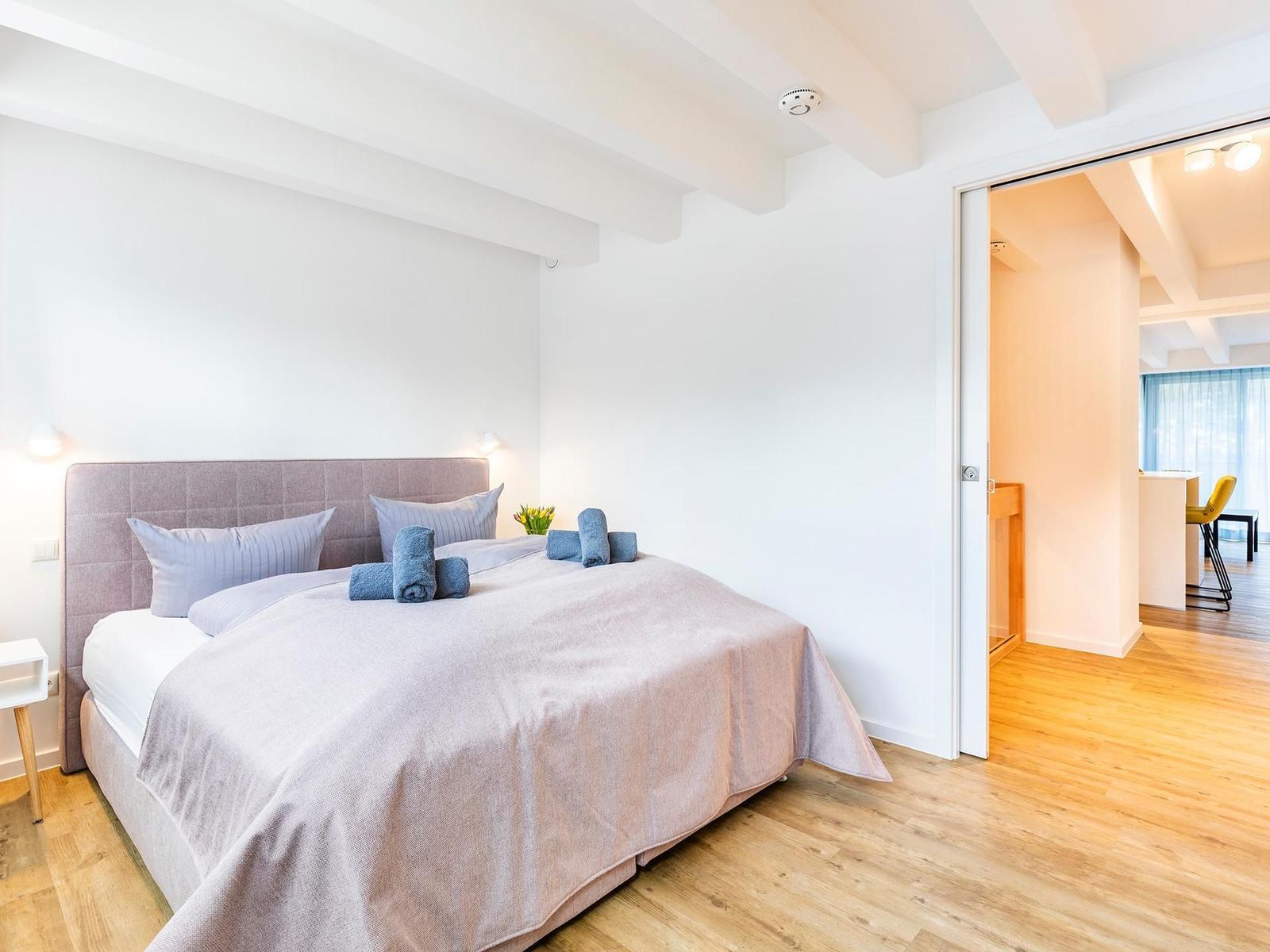 Schlafzimmer 2 (Landseite): Boxspringbett (180x200), Sideboard, Garderobenständer, TV-Flachbild, Gardinen