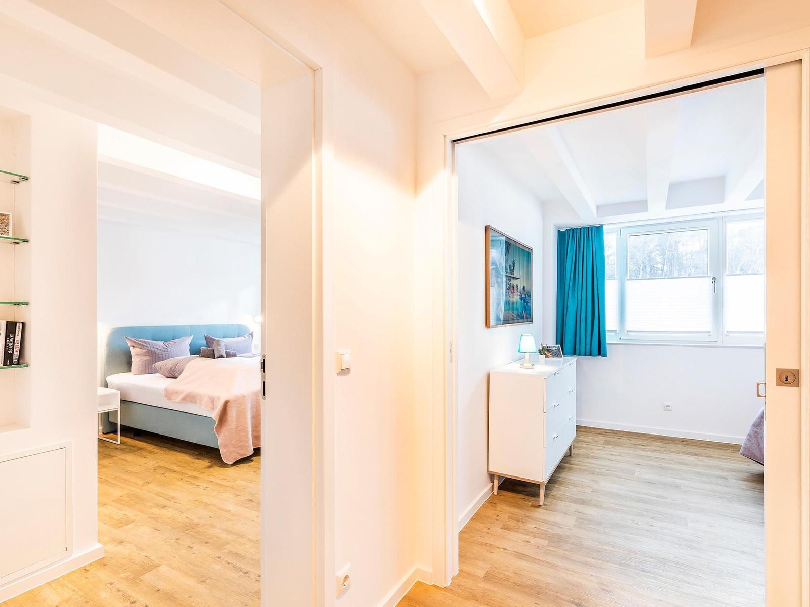 Schlafzimmer 2 (Landseite): Boxspringbett (180x200), Sideboard, Garderobenständer, TV-Flachbild, Gardinen