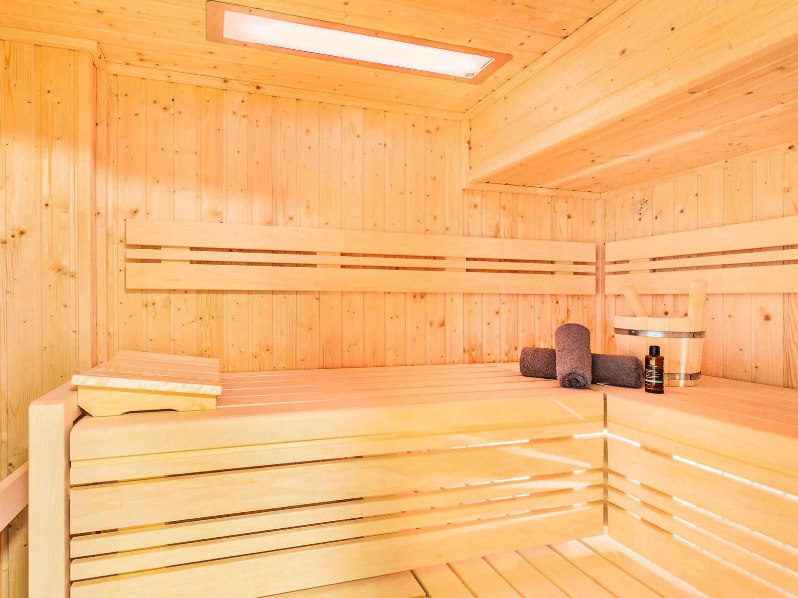 Sauna mit Holzbank, Handtuch und Eimer