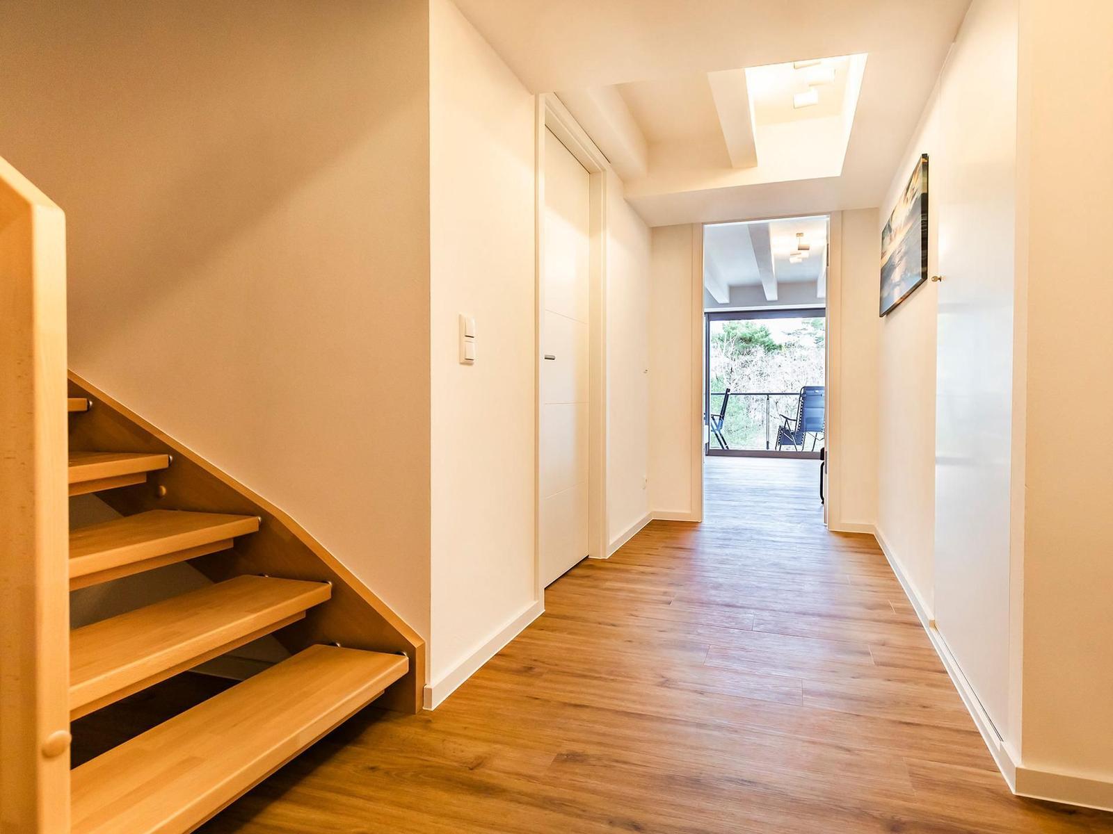 Hallenflur mit Holztreppe und Blick auf Balkon