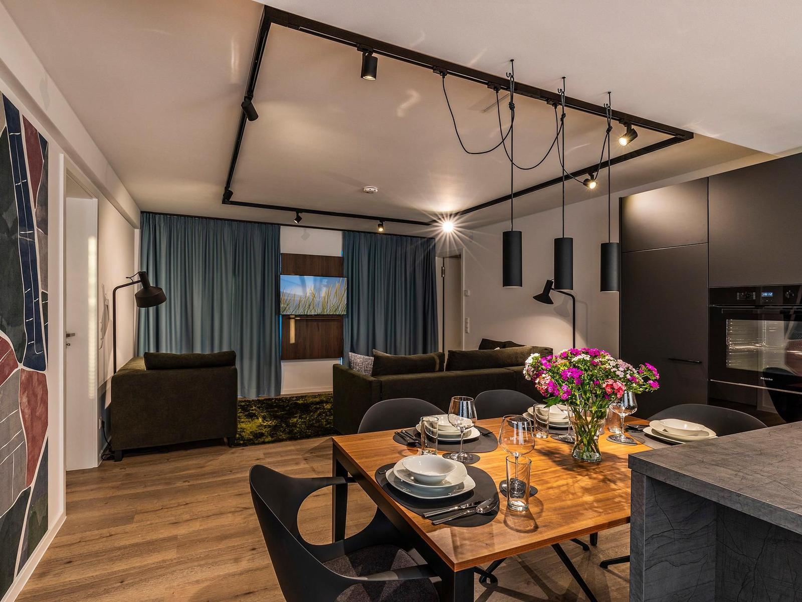 Wohn-/Essbereich: Couchgruppe mit Tisch, Smart-TV, Essbereich, Zugang zum Balkon mit Tisch und Stühlen (Seeseite), Sonn