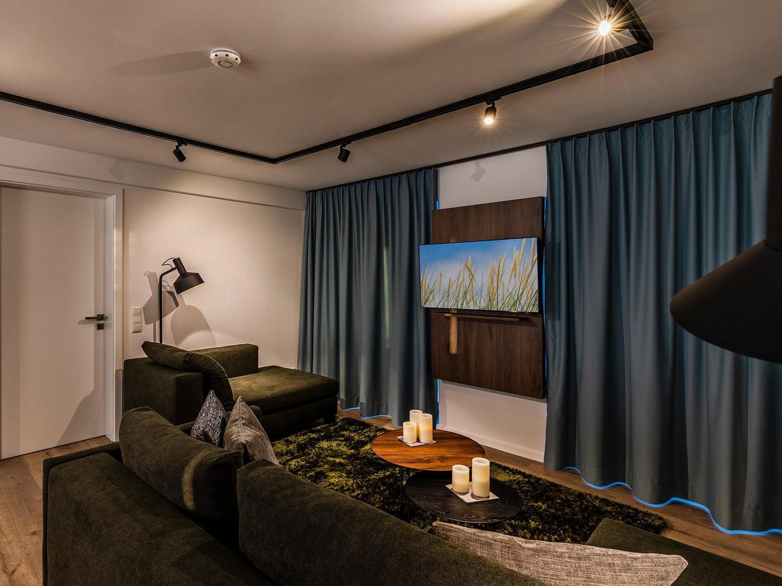 Wohn-/Essbereich: Couchgruppe mit Tisch, Smart-TV, Essbereich, Zugang zum Balkon mit Tisch und Stühlen (Seeseite), Sonn