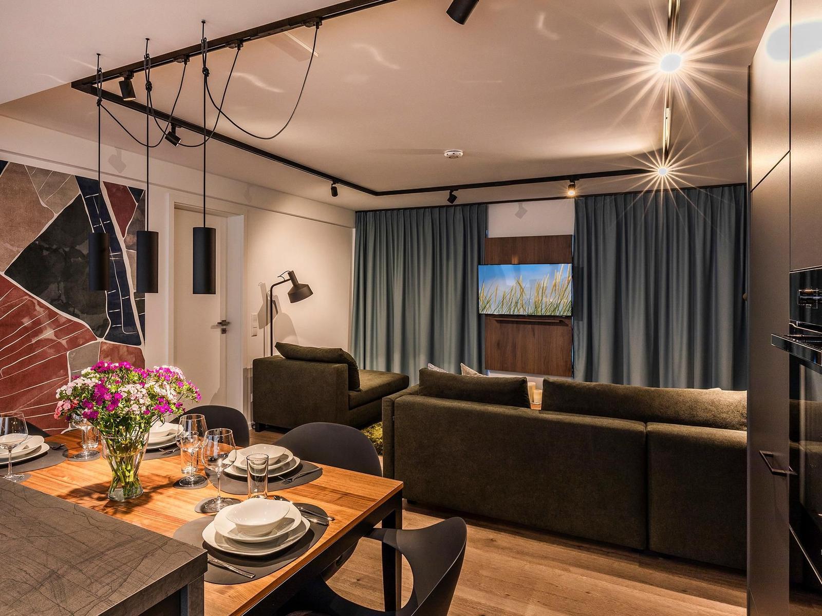 Wohn-/Essbereich: Couchgruppe mit Tisch, Smart-TV, Essbereich, Zugang zum Balkon mit Tisch und Stühlen (Seeseite), Sonn