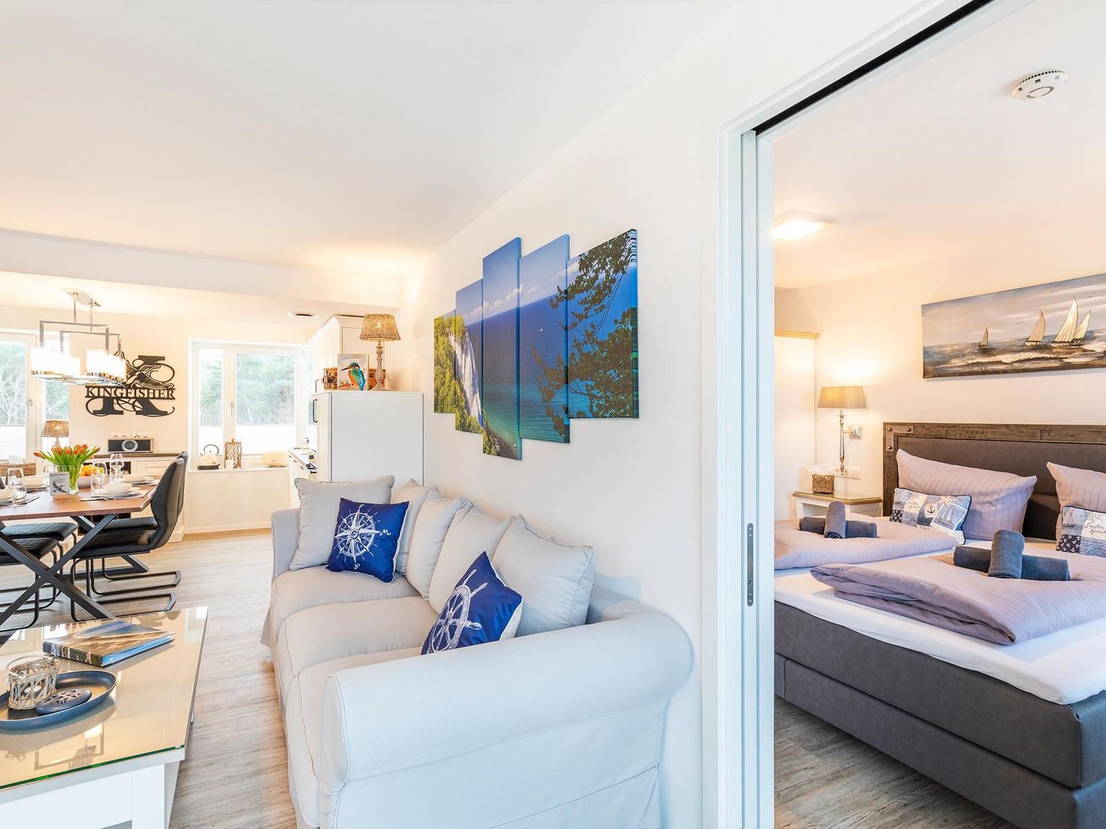 Wohn-/Essbereich: Sofa, Smart-TV, Essbereich, Treppenaufgang zur Dachterrasse, Zugang zum Balkon