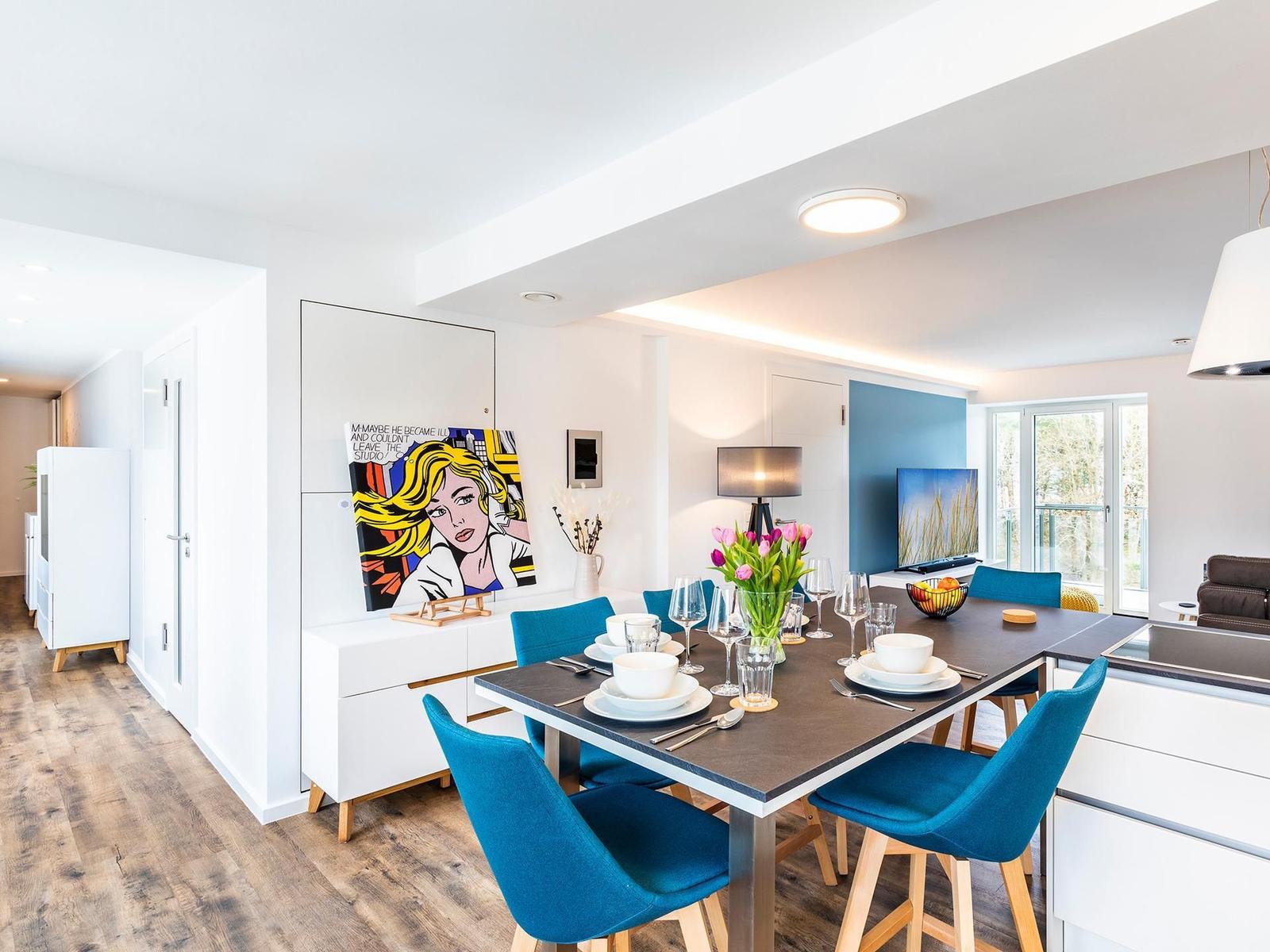 Essbereich mit blauen Stühlen und moderner Wanddekoration.