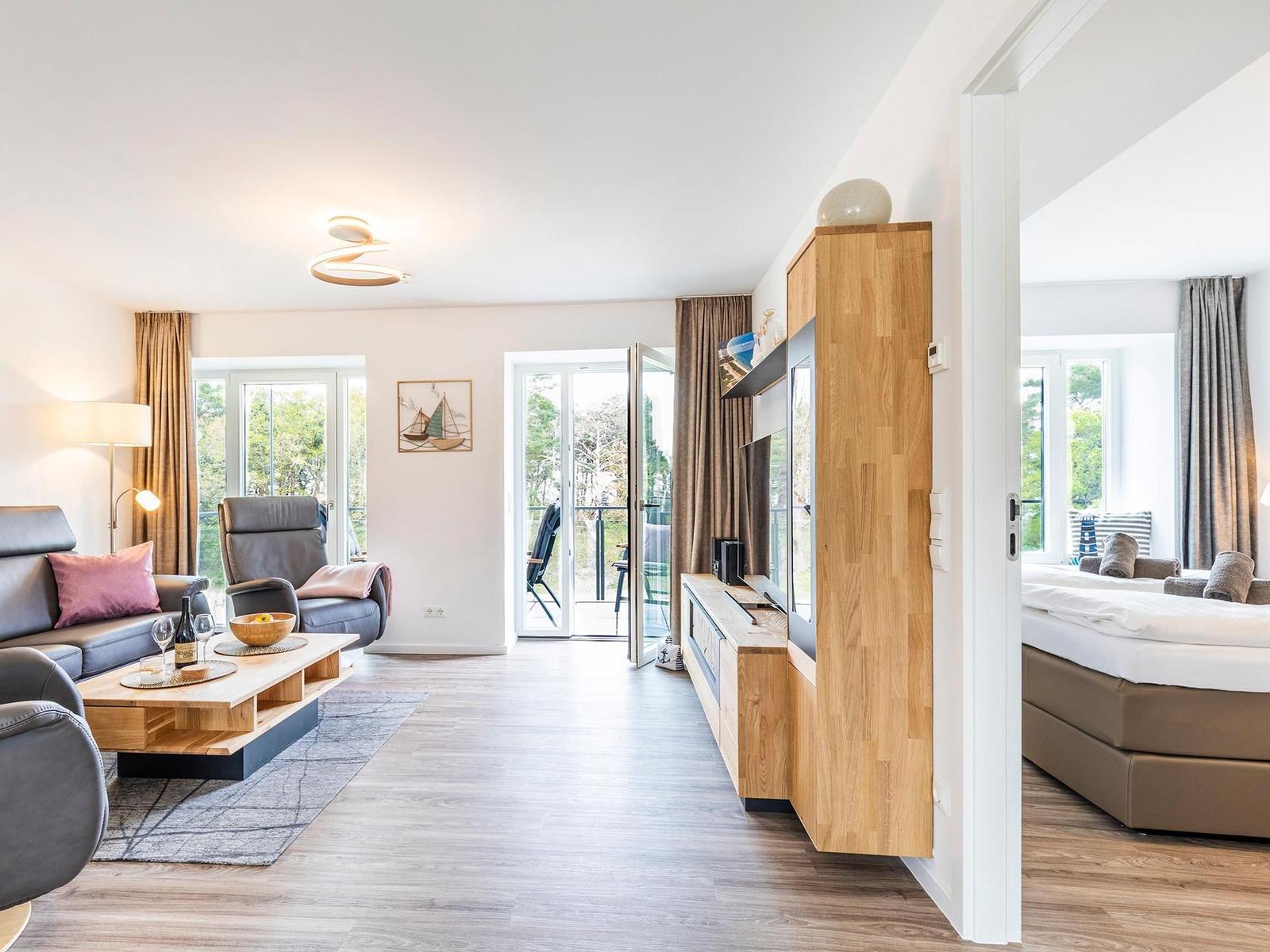 Wohnzimmer: Sofa, 2 Sessel, TV, Zugang zum Balkon