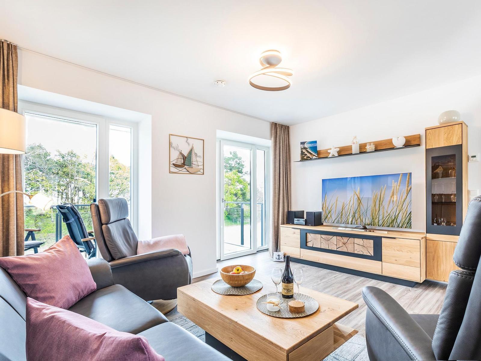 Wohnzimmer: Sofa, 2 Sessel, TV, Zugang zum Balkon