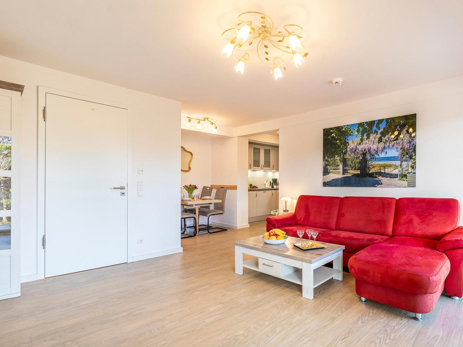 Wohnzimmer: Couch, TV, Essbereich, Zugang zum Balkon